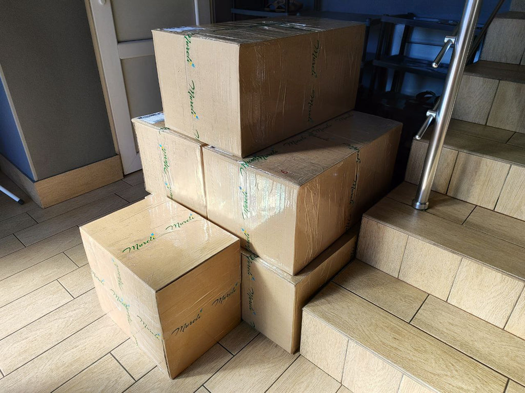 Stacked cardboard boxes with Mureli branding, ready for daily 100 kg shipments to the U.S. before Christmas