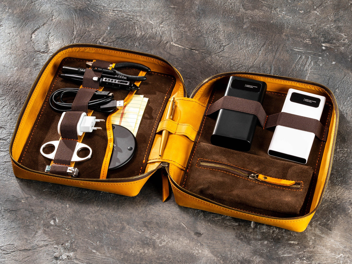 Golden Yellow zippered leather travel organizer filled with chargers, cables, tools and travel essentials