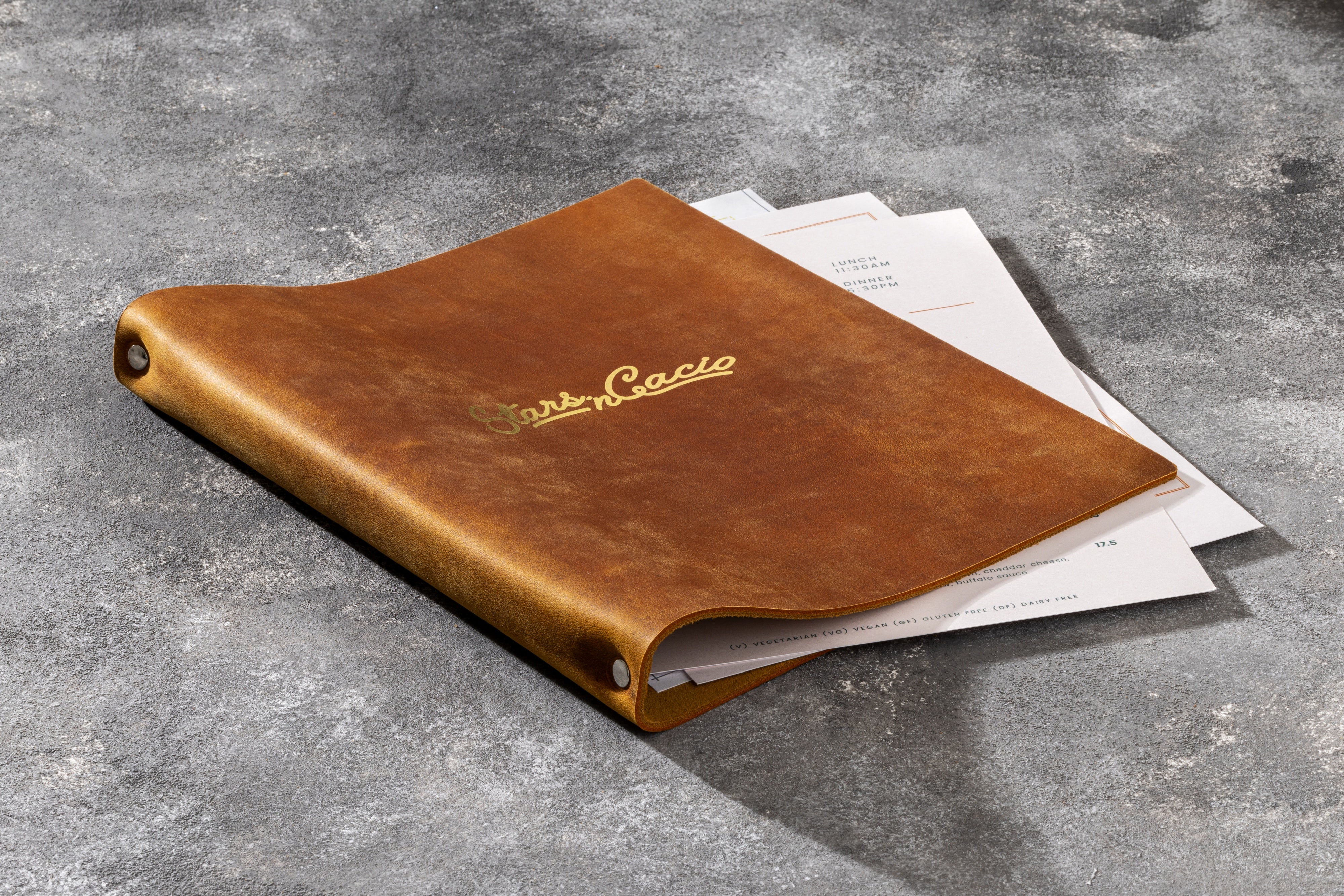 Leather menu cover showing 3-ring binding mechanism inside