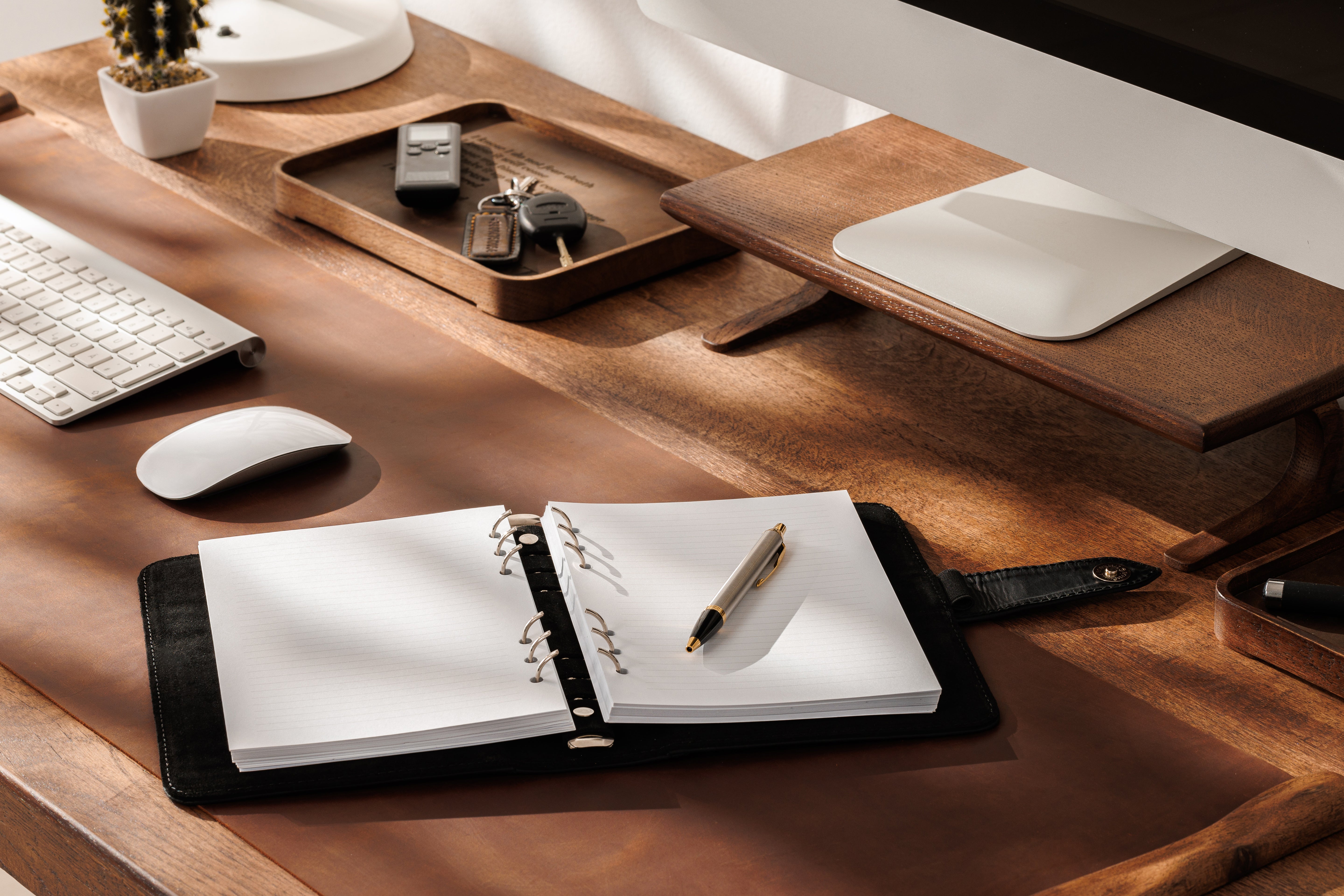 Professional office flat lay with black Mureli notebook, glasses and phone