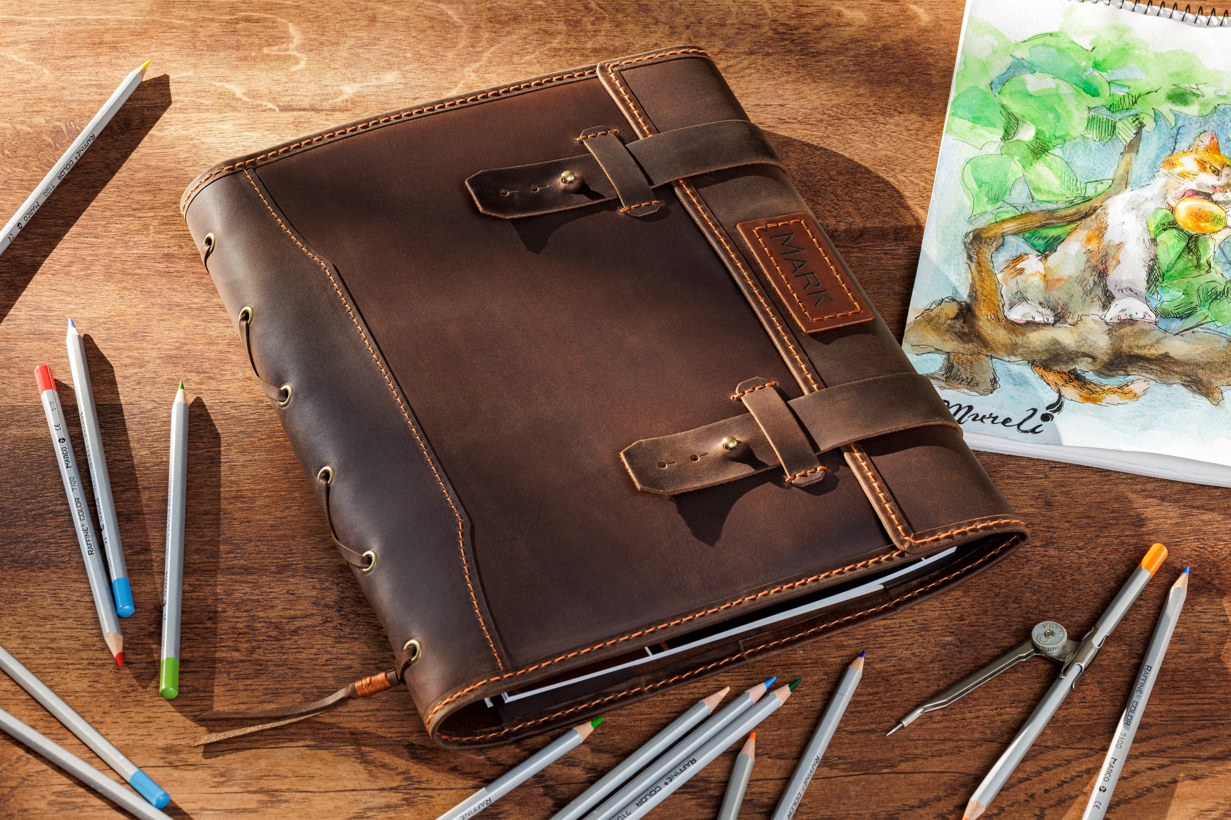 Handcrafted brown leather sketchbook organizer with orange stitching and name patch — La Vita Collection by Mureli