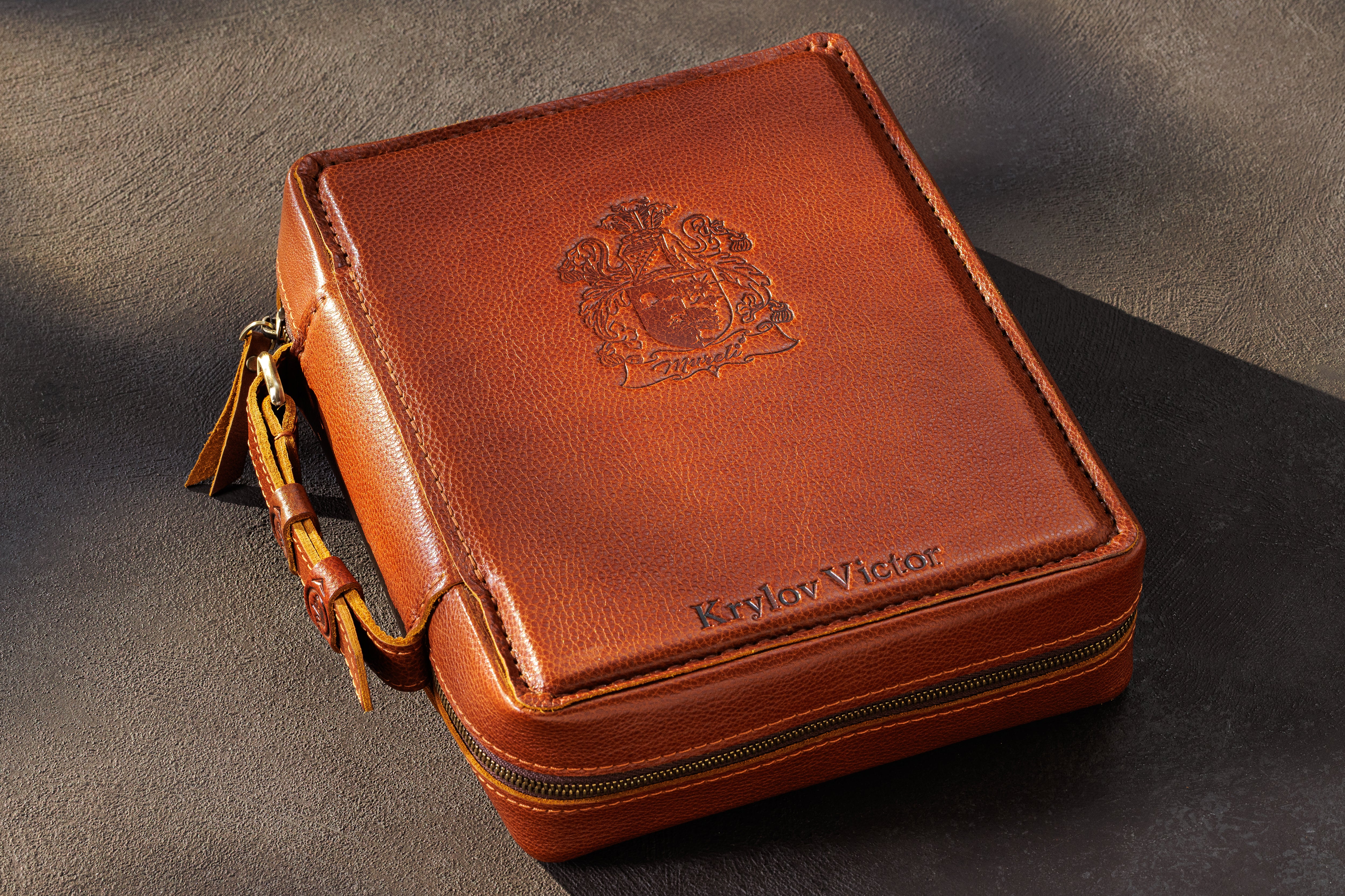 Camel leather money storage case with embossed crest, personalized name and carrying handle