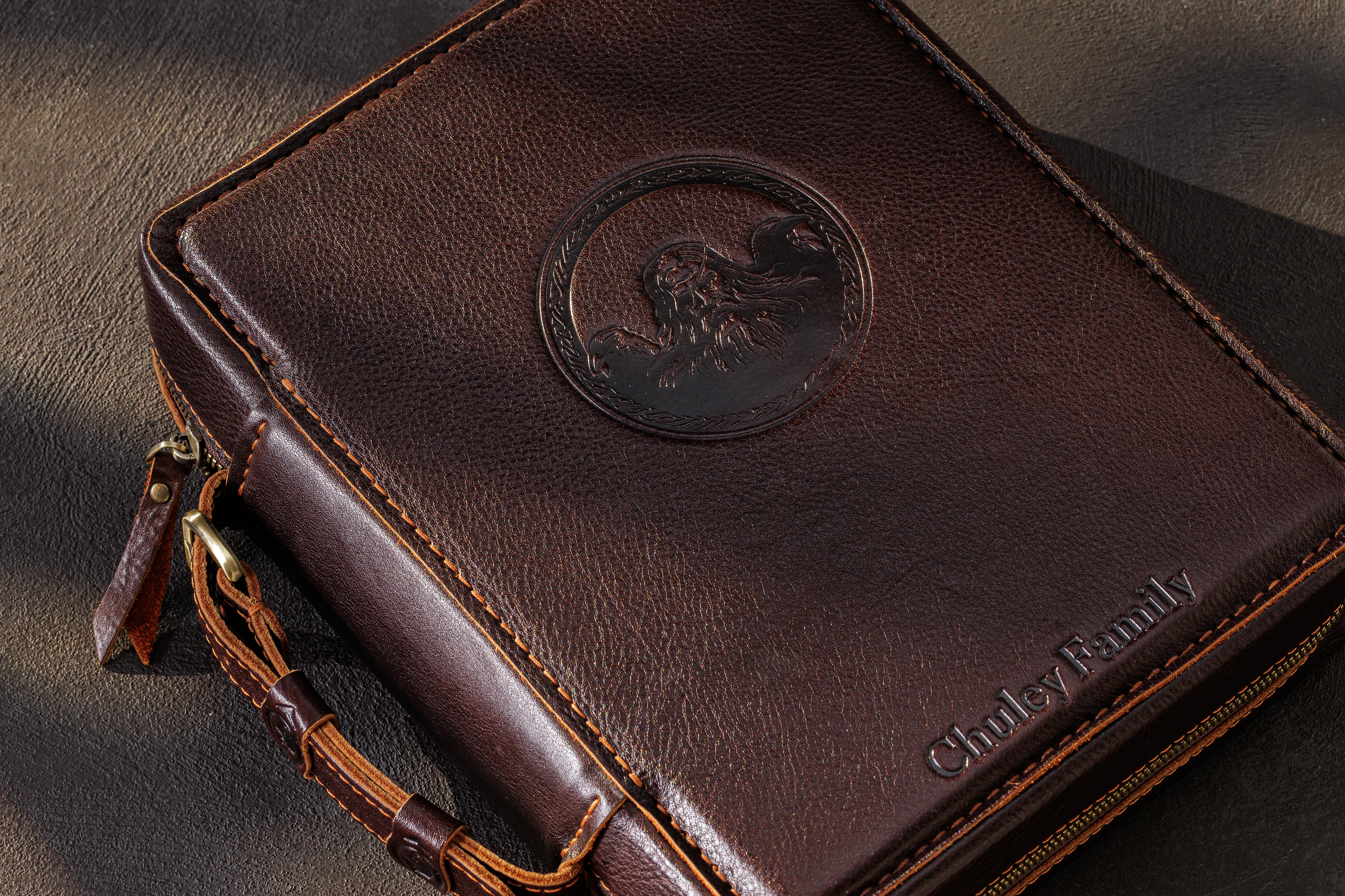 Personalized dark brown leather family cash storage case with embossed medallion, custom family name and zipper closure