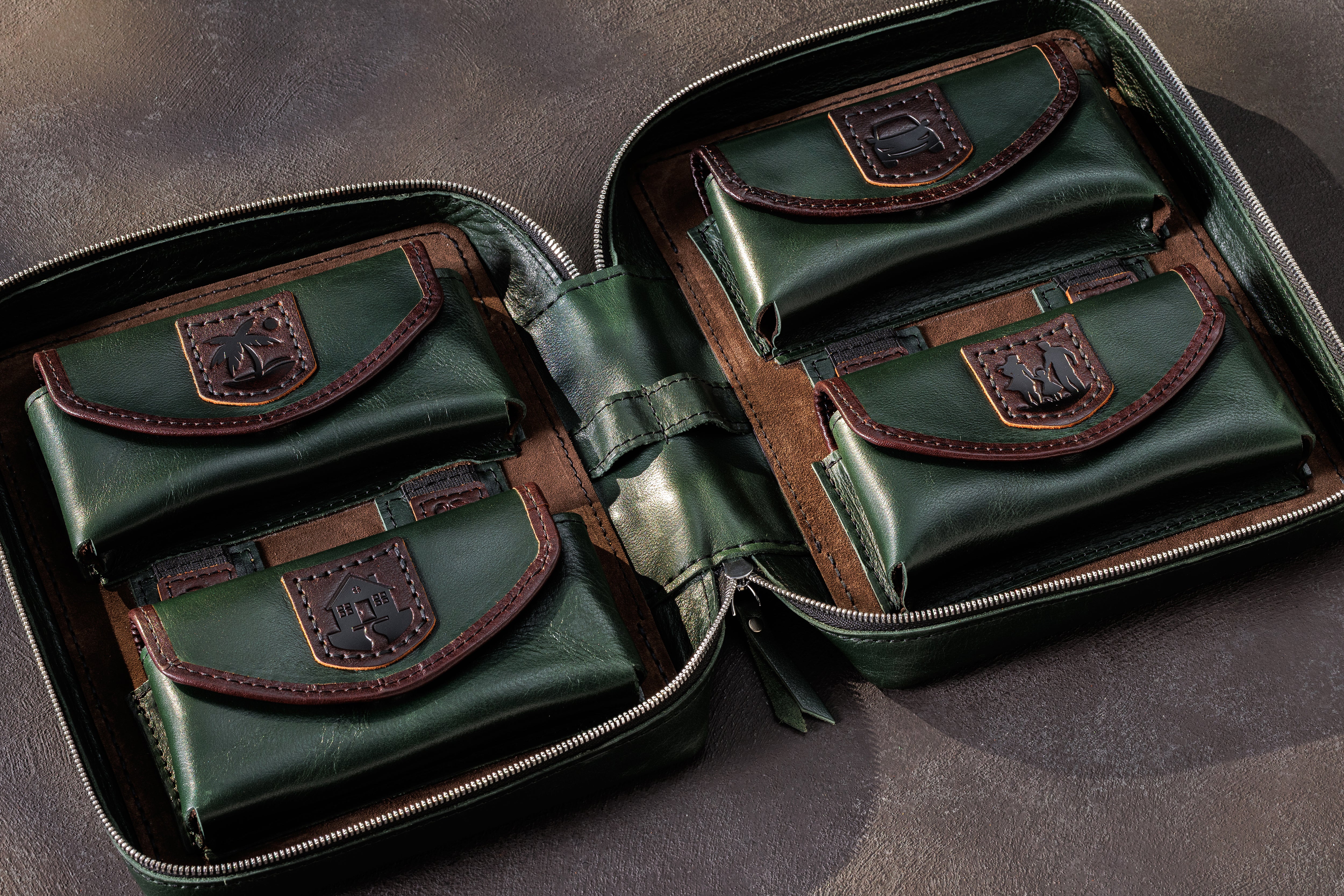 Open dark green leather money organizer with four expandable cash pockets and fixed decorative leather patch designs