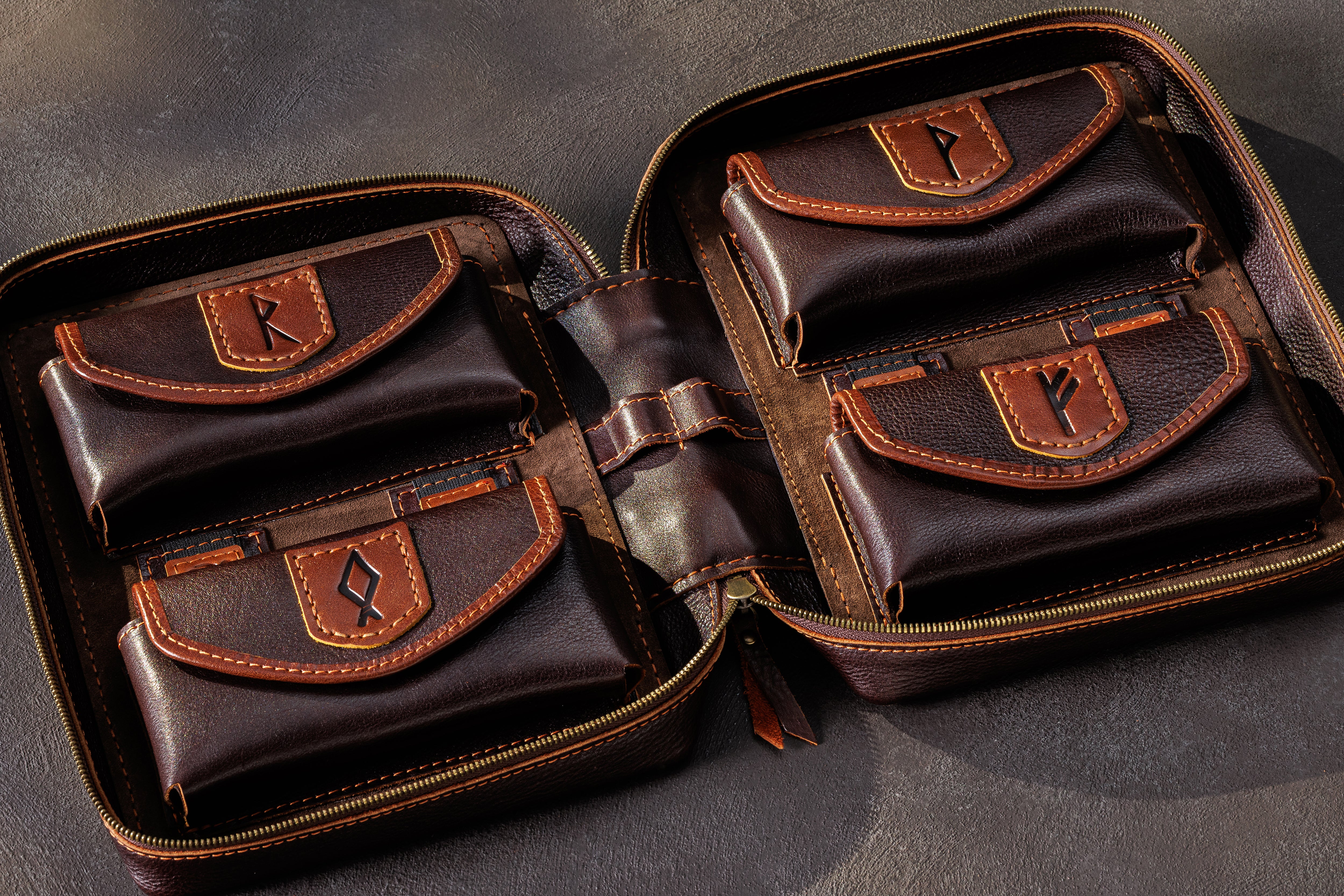 Dark brown leather cash organizer pocket filled with US dollar bills and separate budgeting compartments