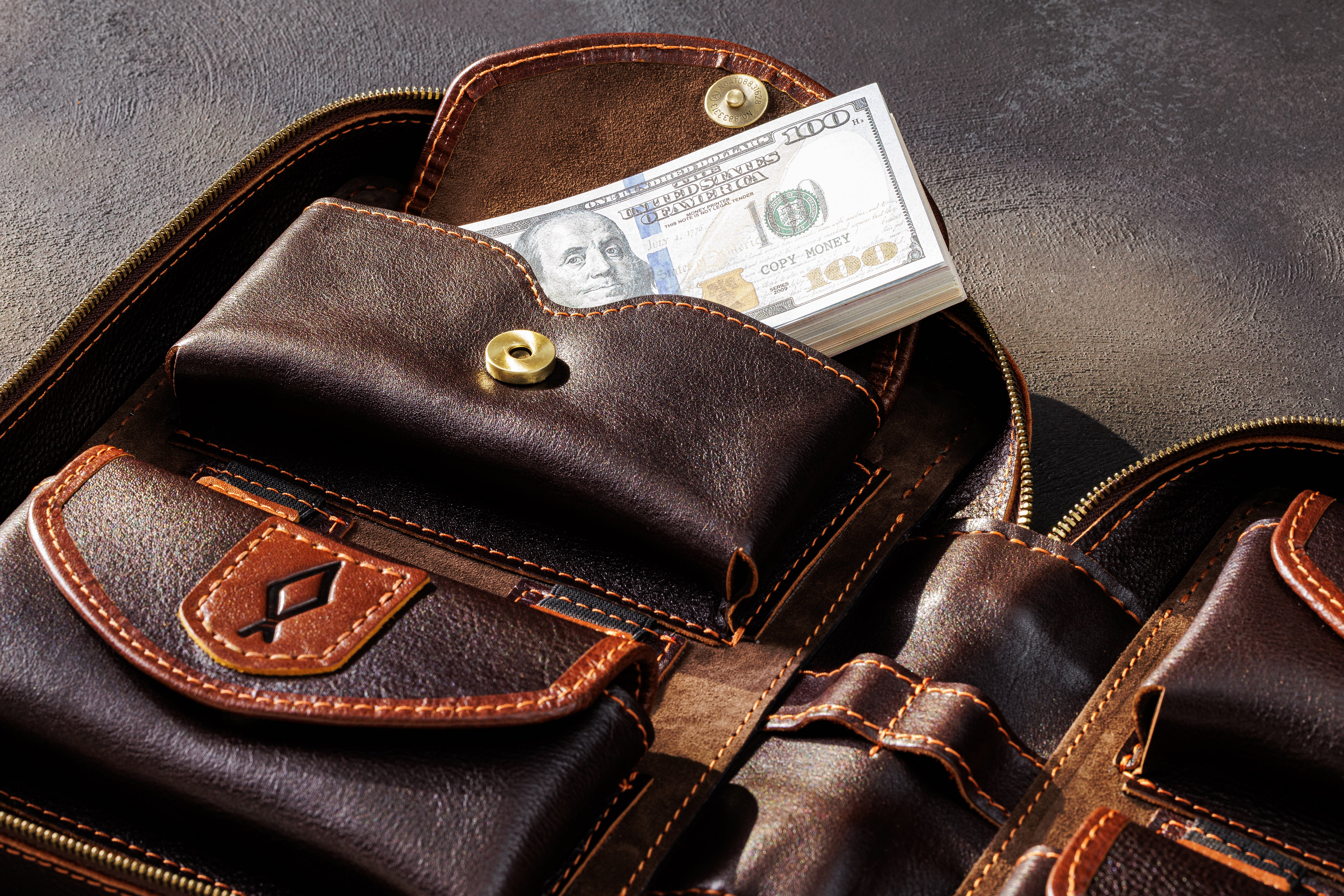 Open dark brown family cash organizer with four expandable money pockets and fixed decorative symbols
