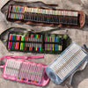 Set of colored pencils in various cases on a concrete surface
