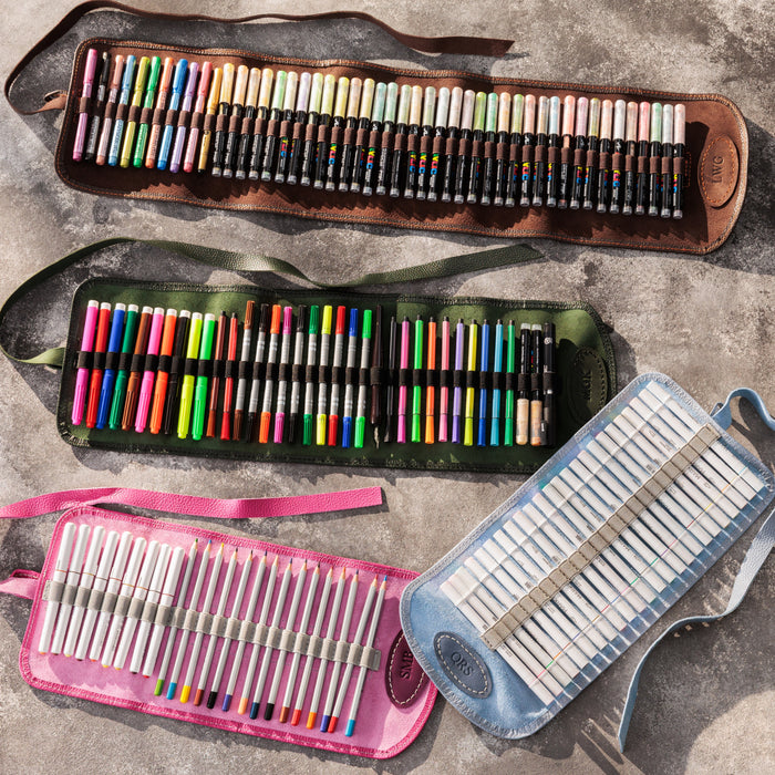 Set of colored pencils in various cases on a concrete surface