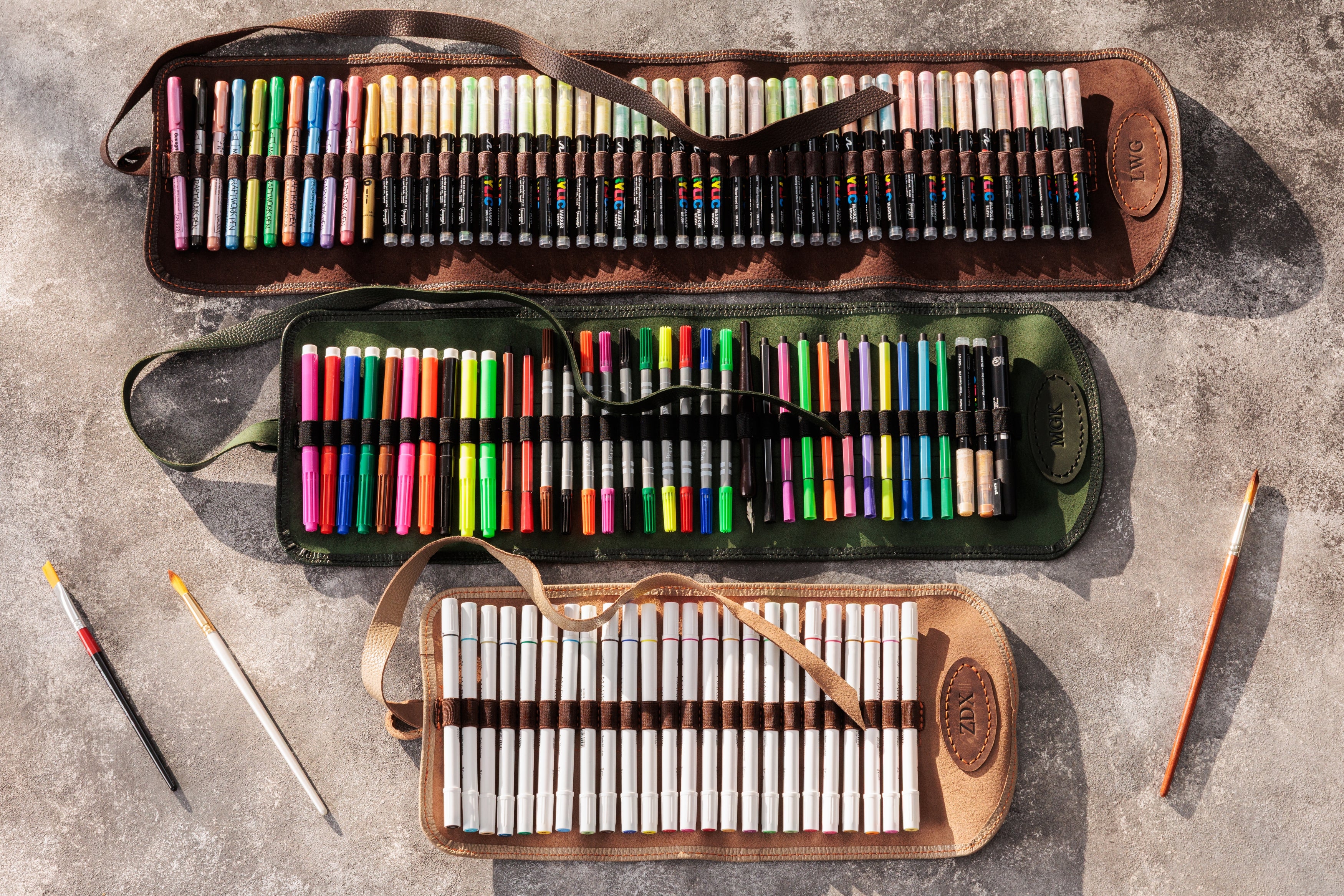 Set of colored pencils in a carrying case on a concrete surface
