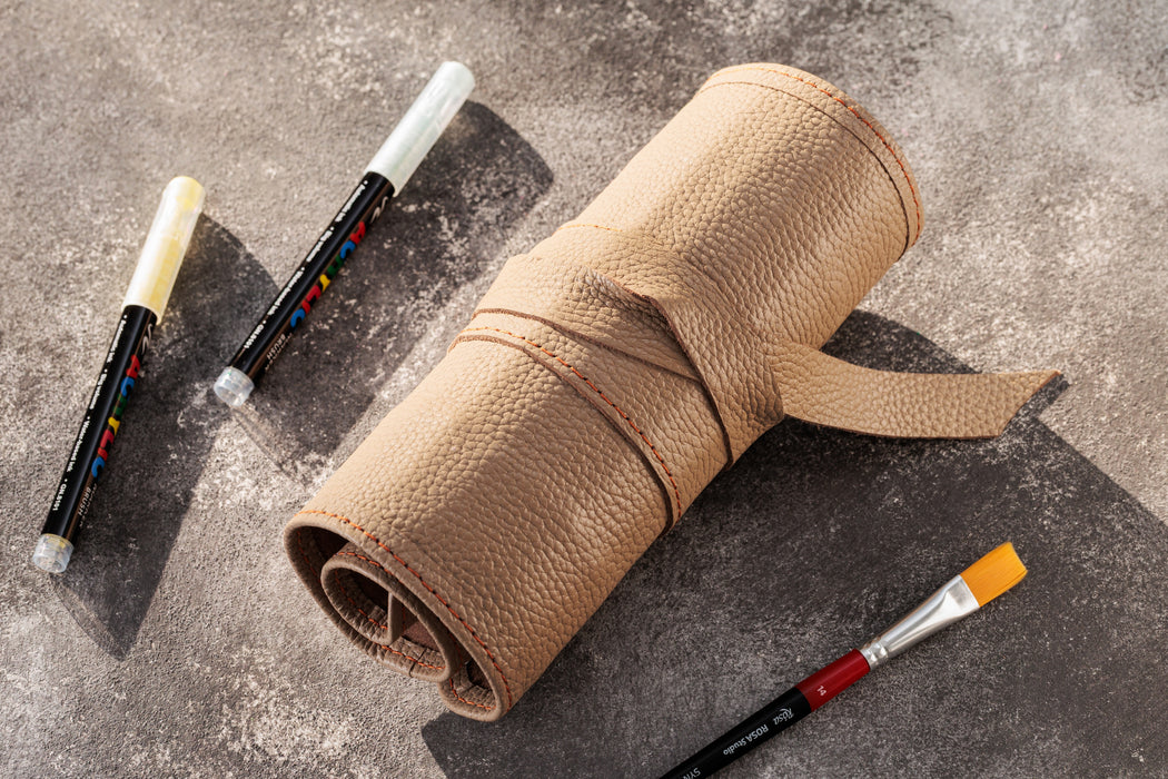 Roll of brown paper with paintbrushes on a gray surface