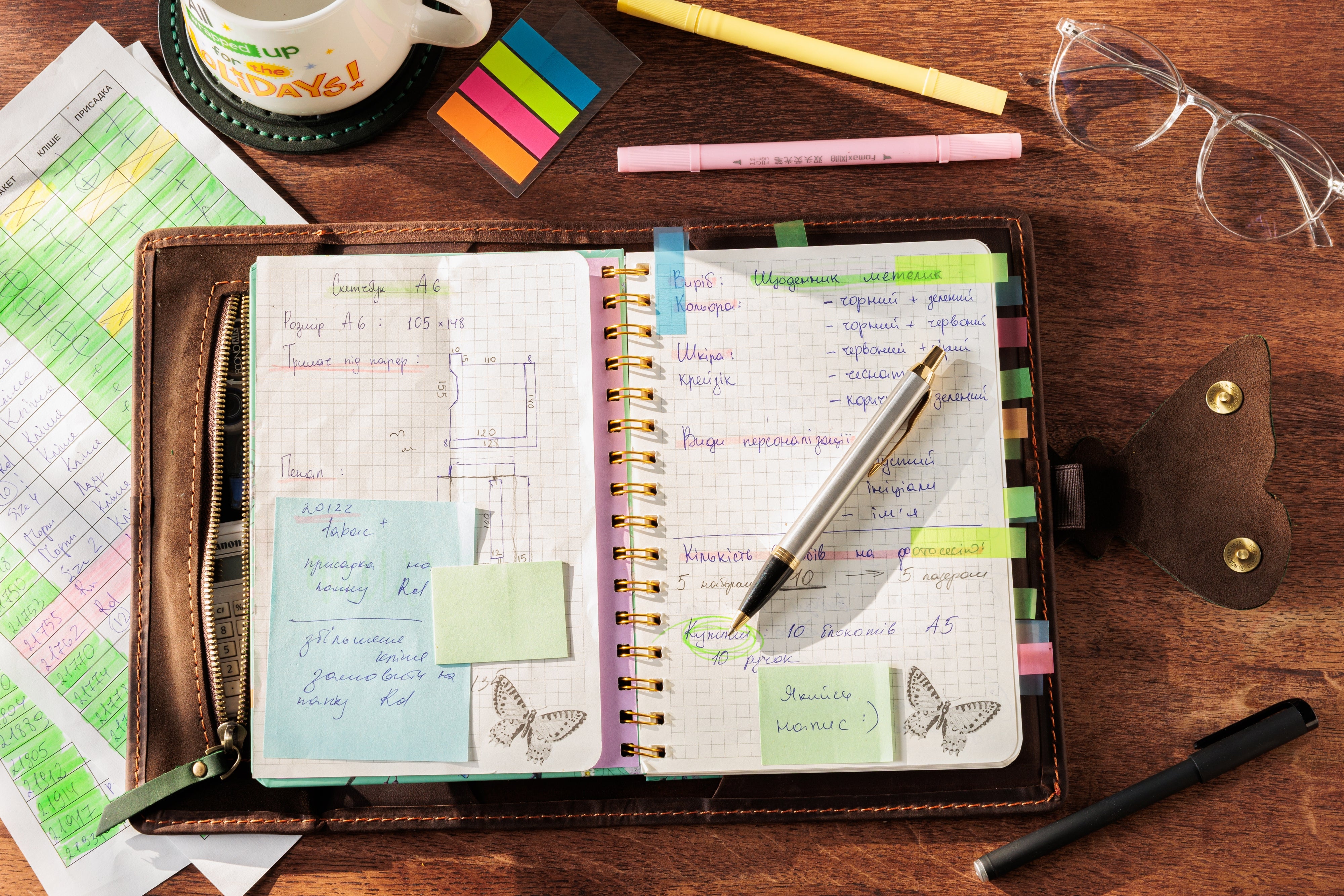 Empty leather organizer with butterfly clasp and compartments.