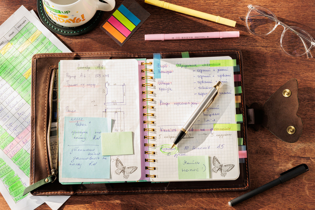 Empty leather organizer with butterfly clasp and compartments.