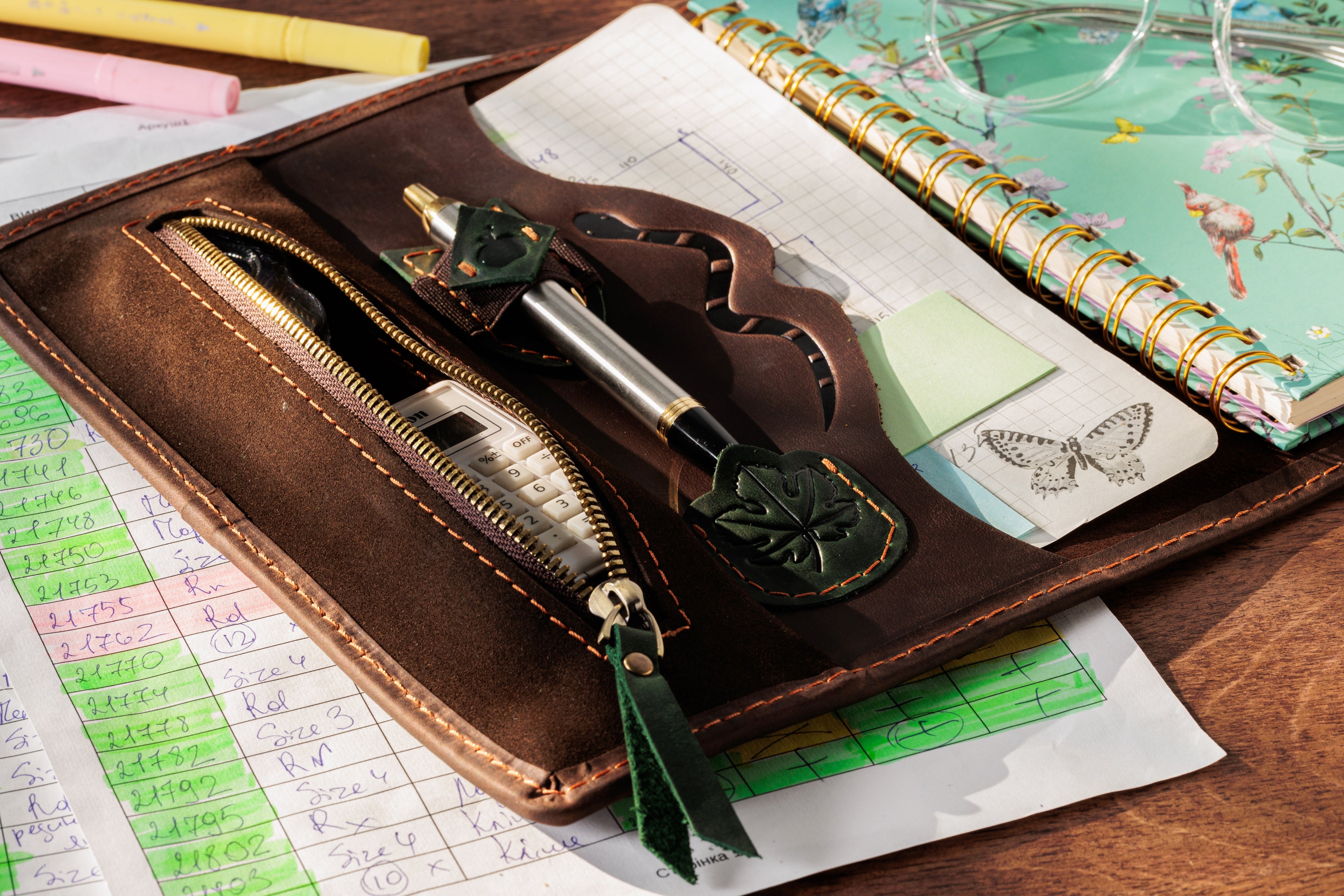 Leather sketchbook organizer with colored pencils and artist notebook.