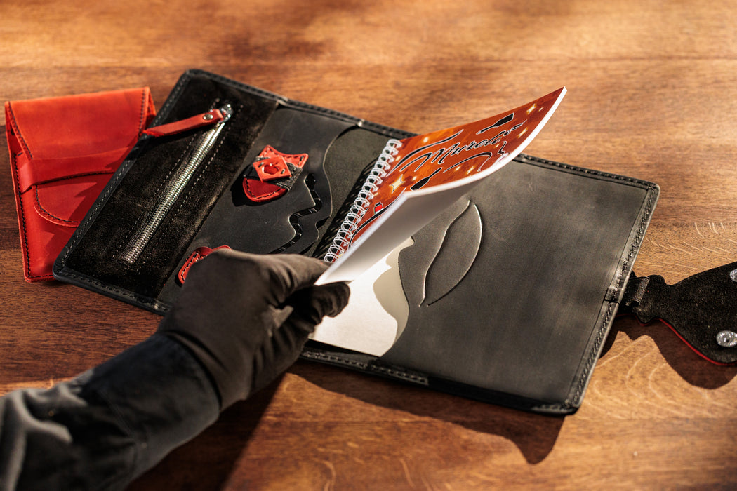 Black and red leather sketchbook organizer with colored pencils set.