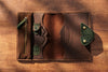 Brown leather organizer with green details and pen holders.