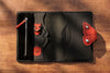 Inside black leather organizer with red details and pen holder.