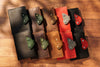 Set of leather wallets in various colors with decorative elements on a wooden surface