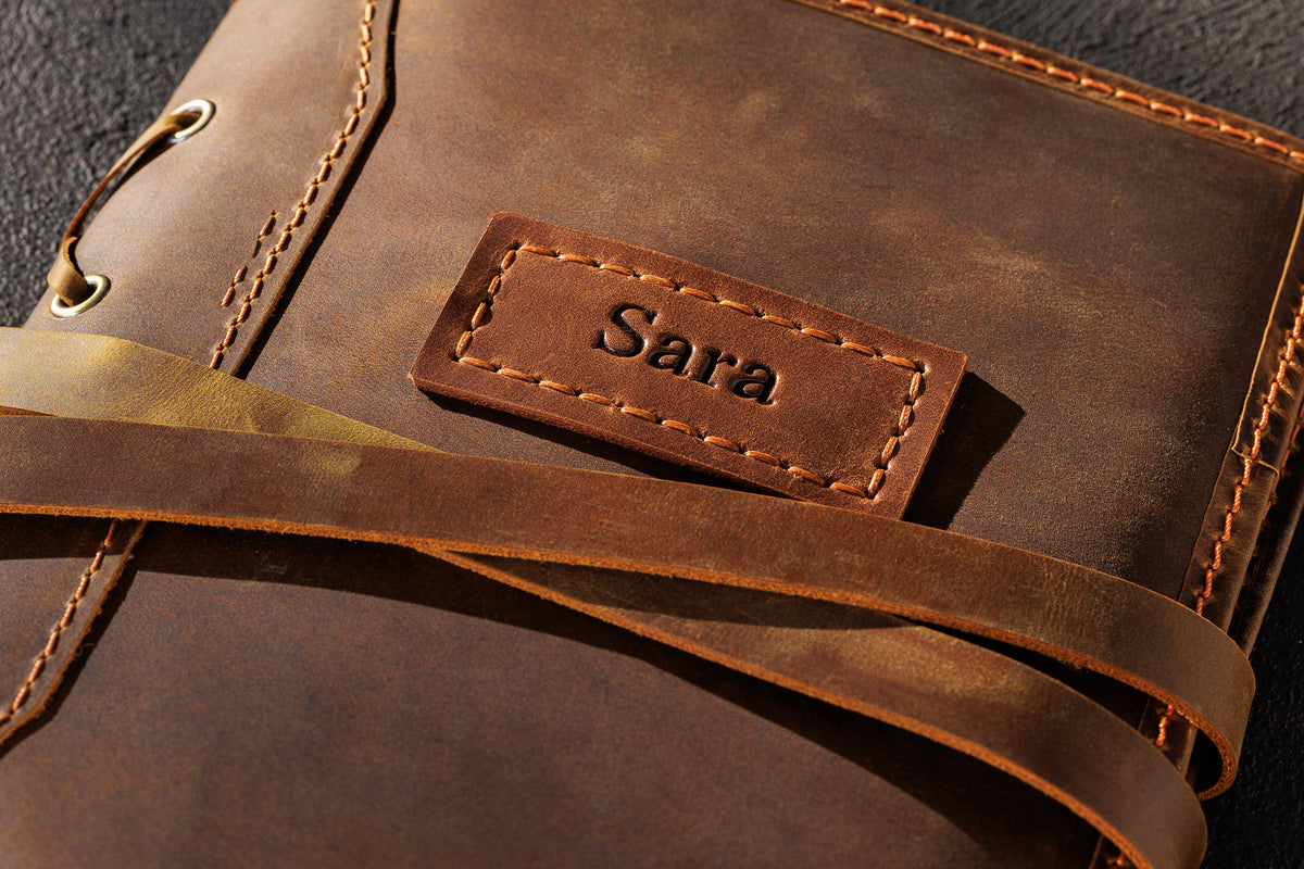 Close-up of personalized Chestnut Crazy Horse leather sketchbook cover with name tag