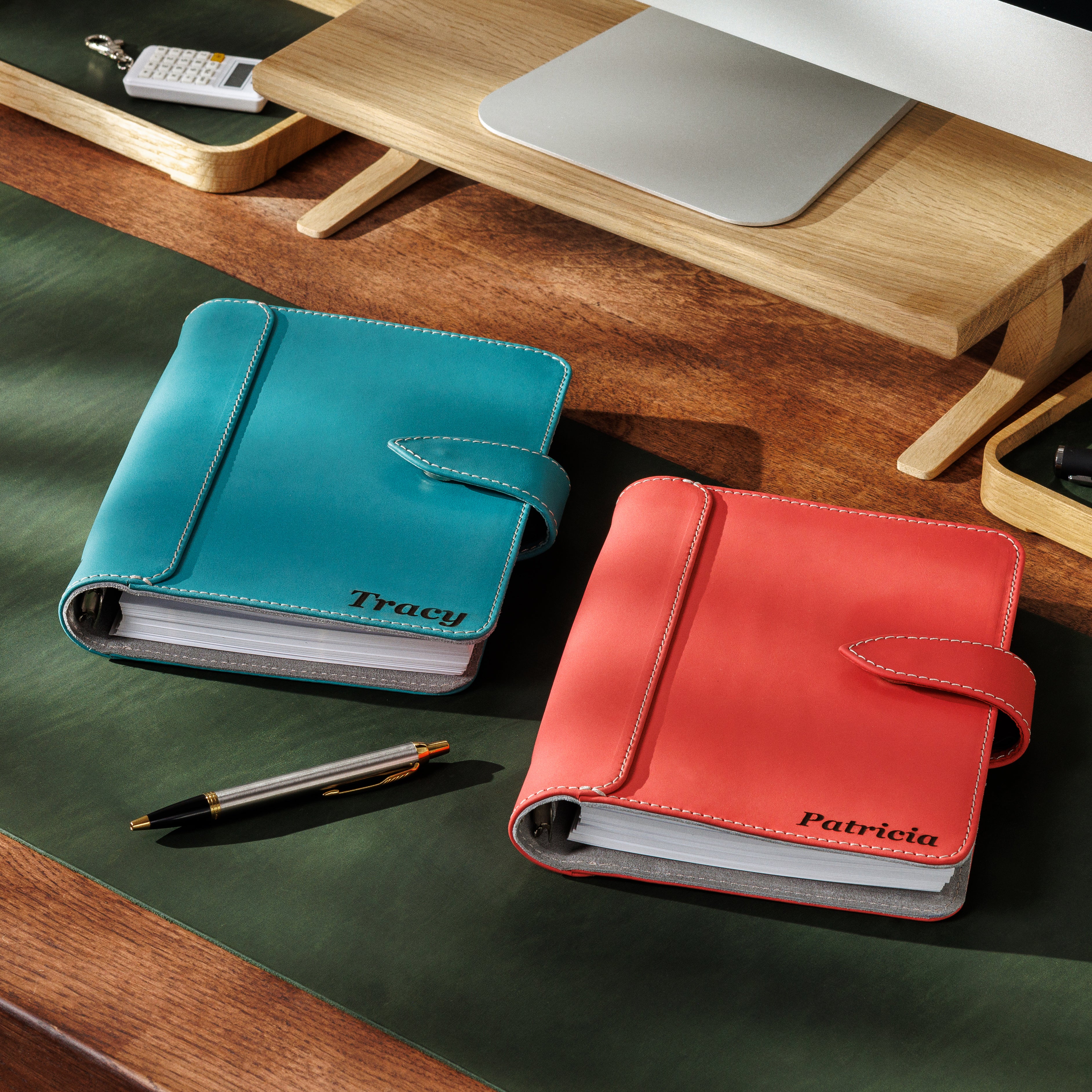 Turquoise leather planner open on desk with card slots and ring binder system