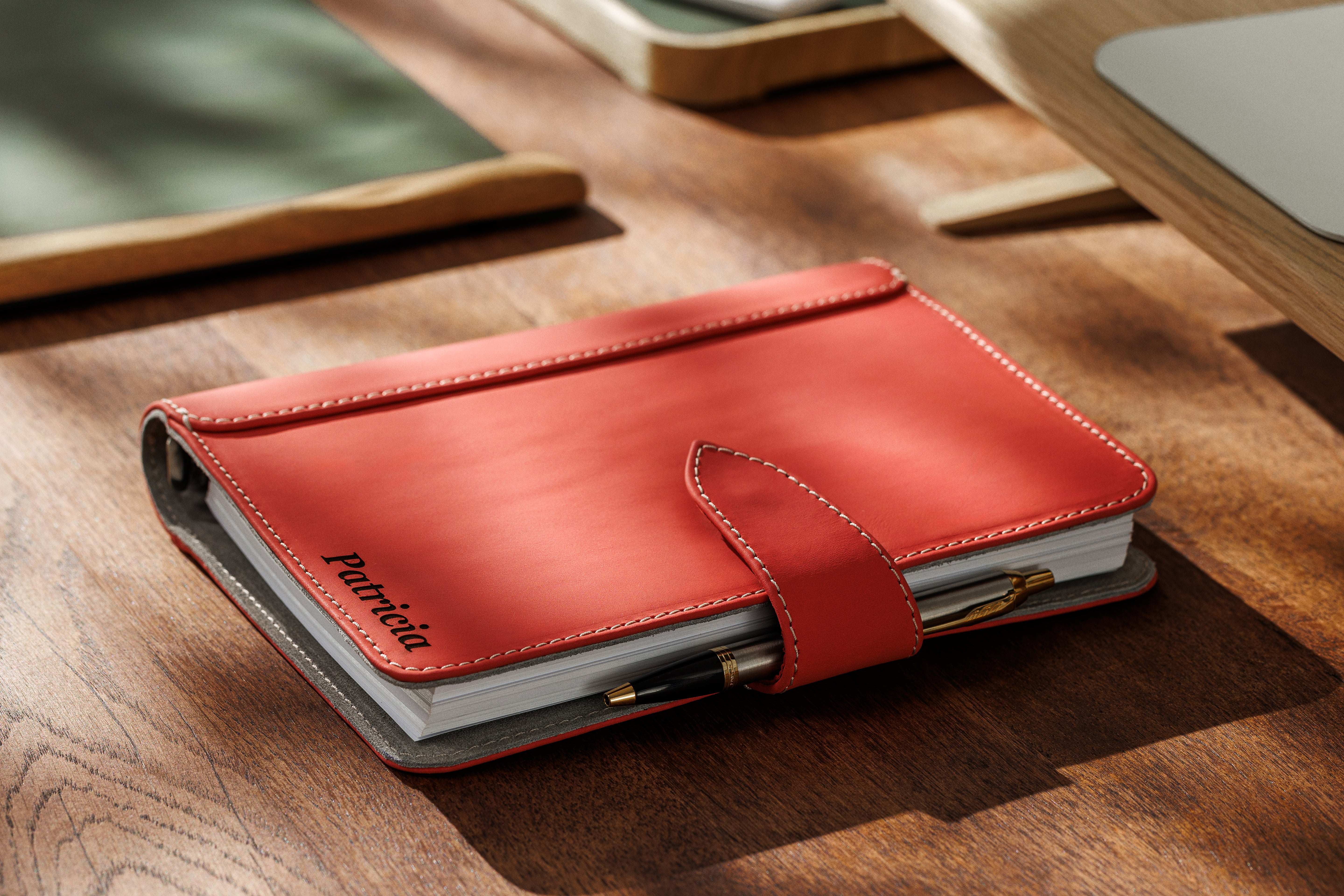Close-up of coral Mureli notebook with visible stitching and luxury finish