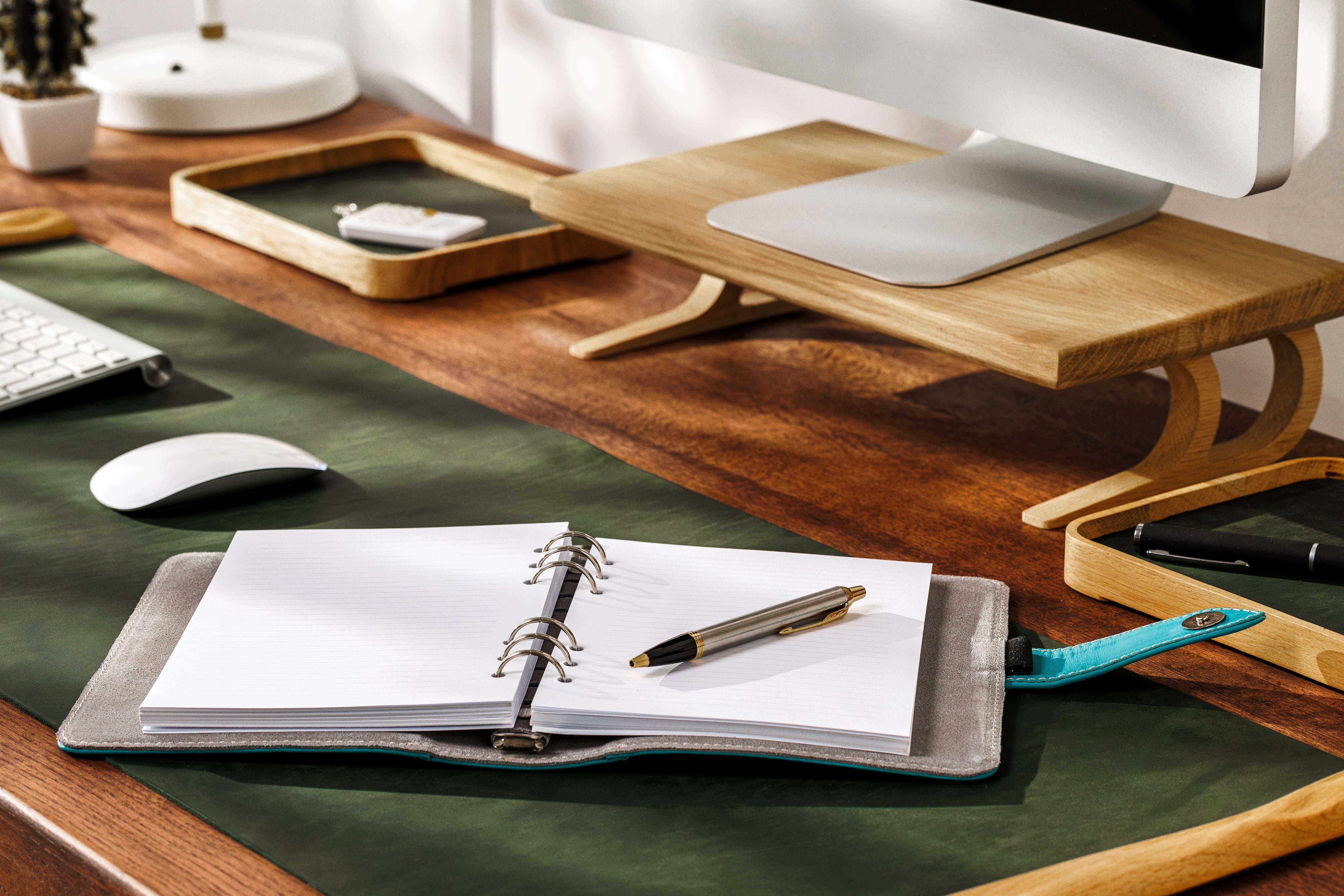 Flat lay of sky blue leather binder surrounded by modern work accessories