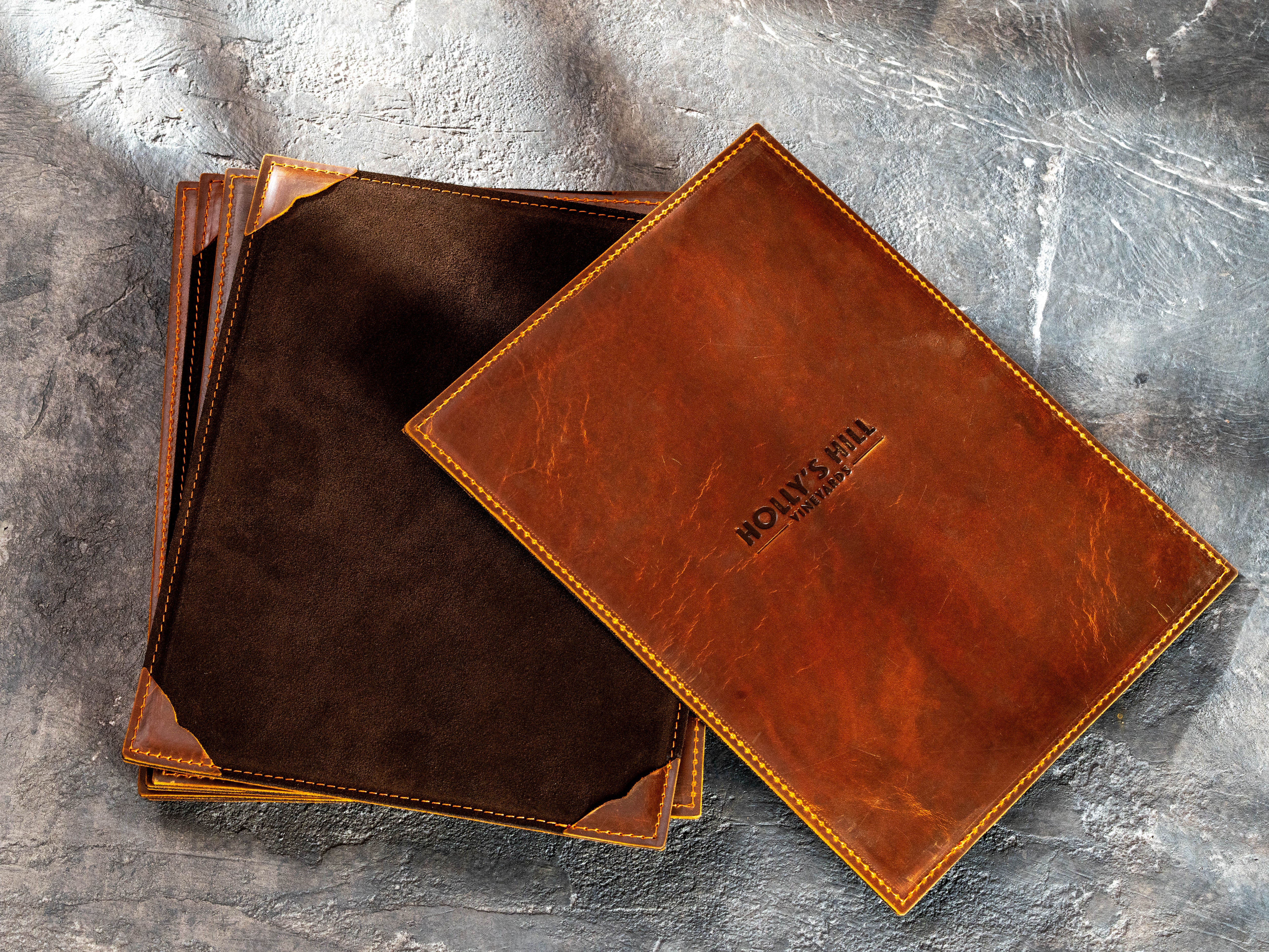 Chestnut leather menu boards made for Holly’s Hill Vineyards with brown suede backing and custom embossed logo