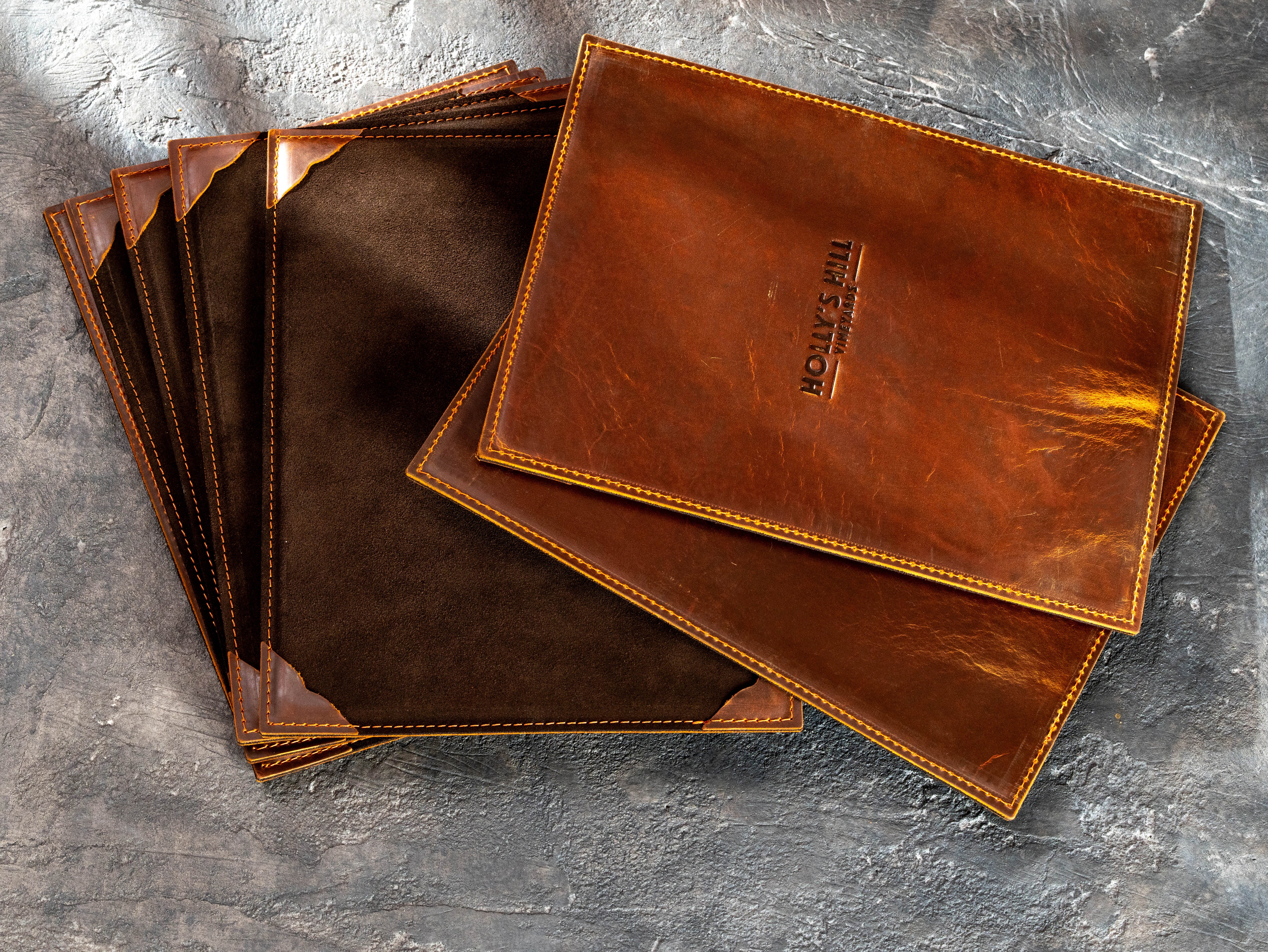 Custom Chestnut Crazy Horse leather single-page menu boards with brown suede backs and embossed Holly’s Hill Vineyards logo