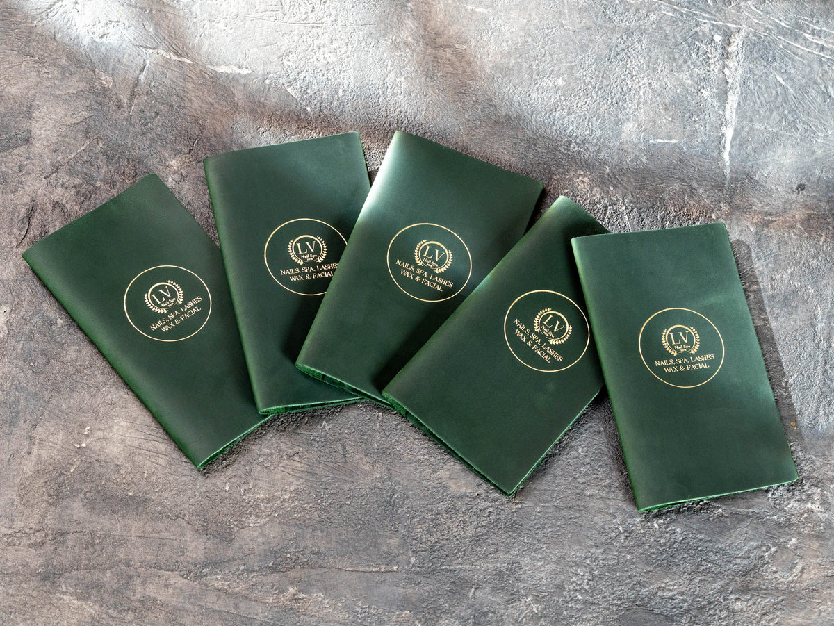 Custom green leather check presenters with gold logo made for a nail spa business