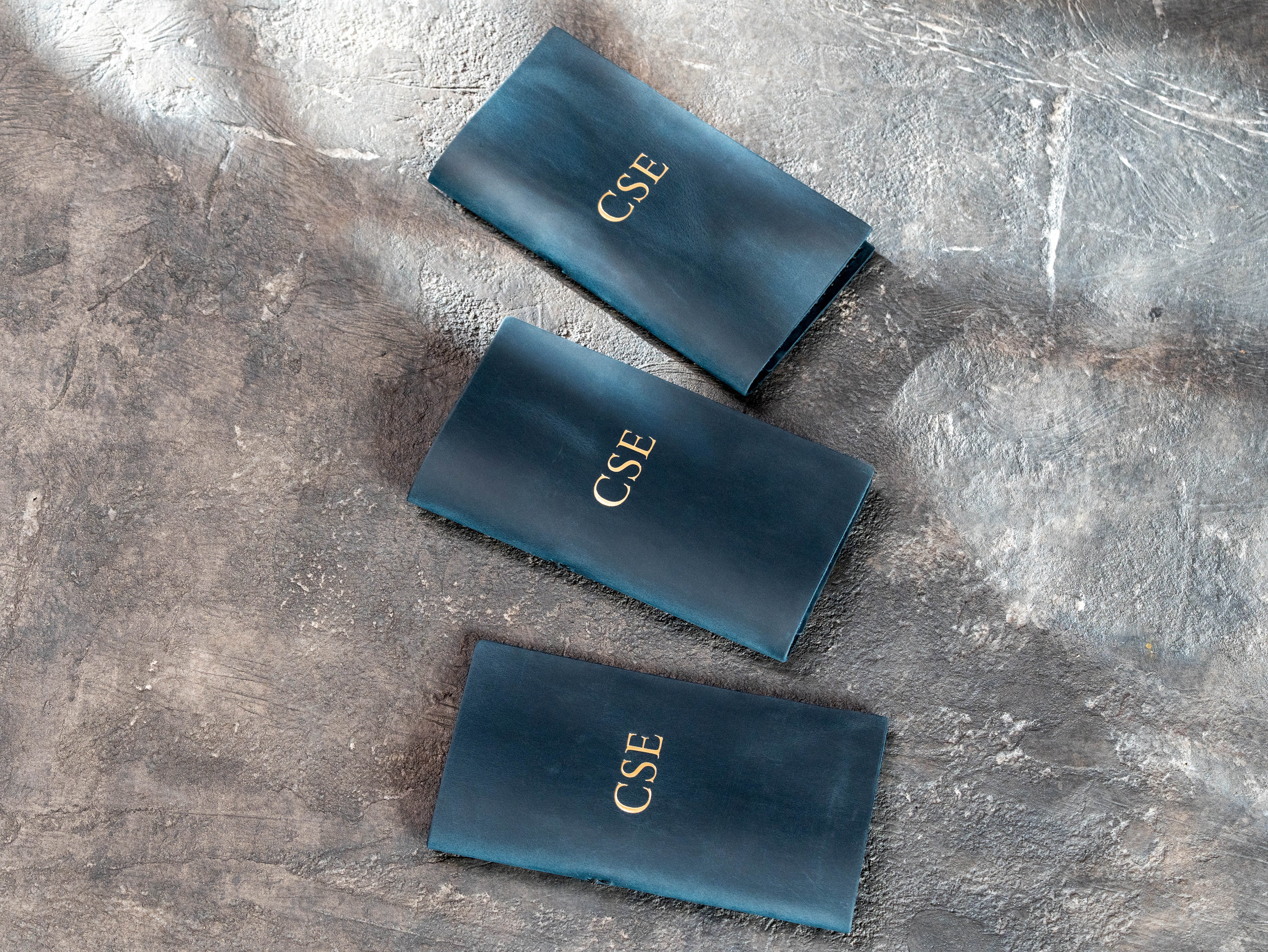 3 custom blue leather check presenters with gold CSE initials