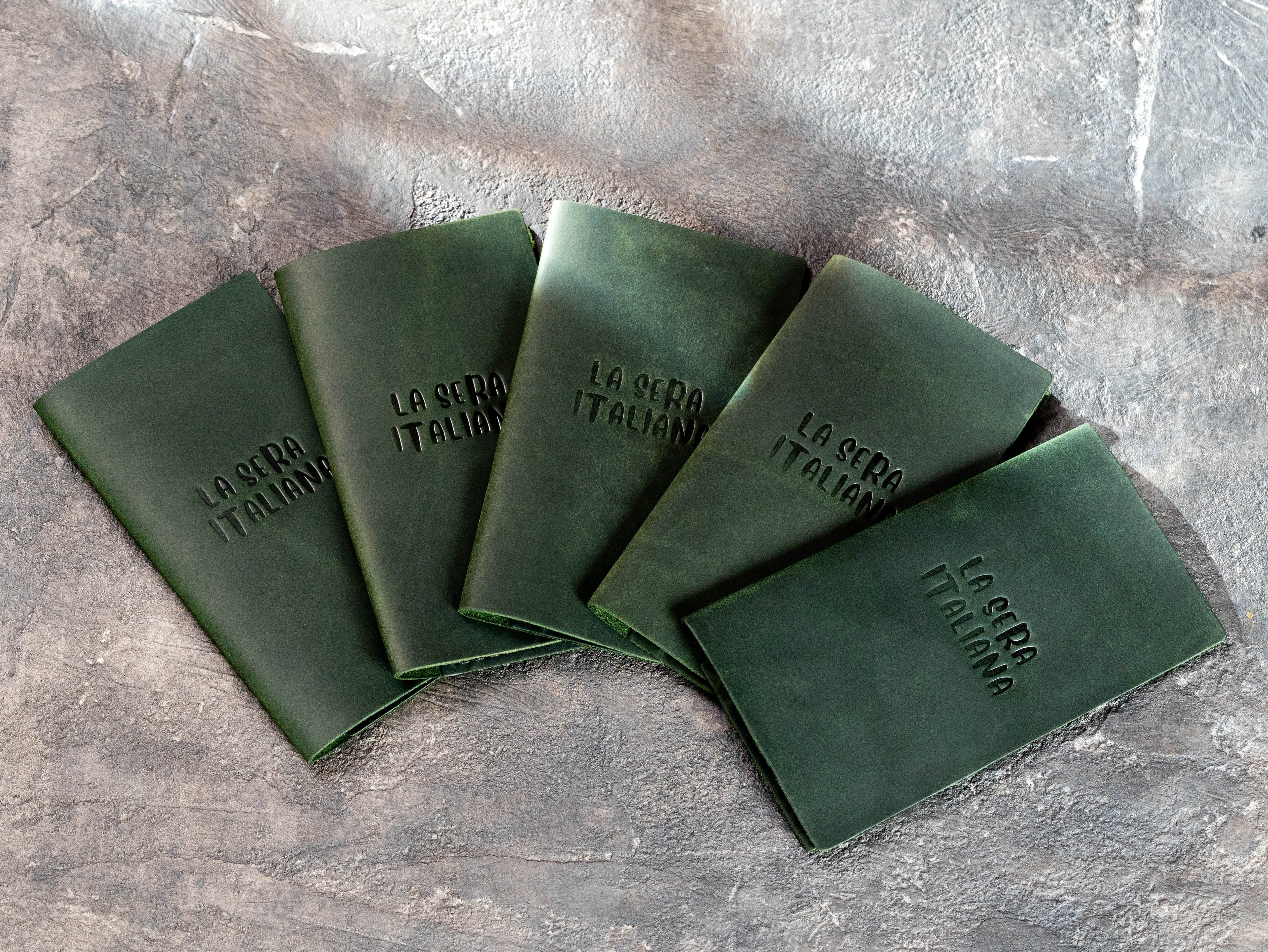 Dark green leather restaurant check presenters with blind embossed La Sera Italiana logo