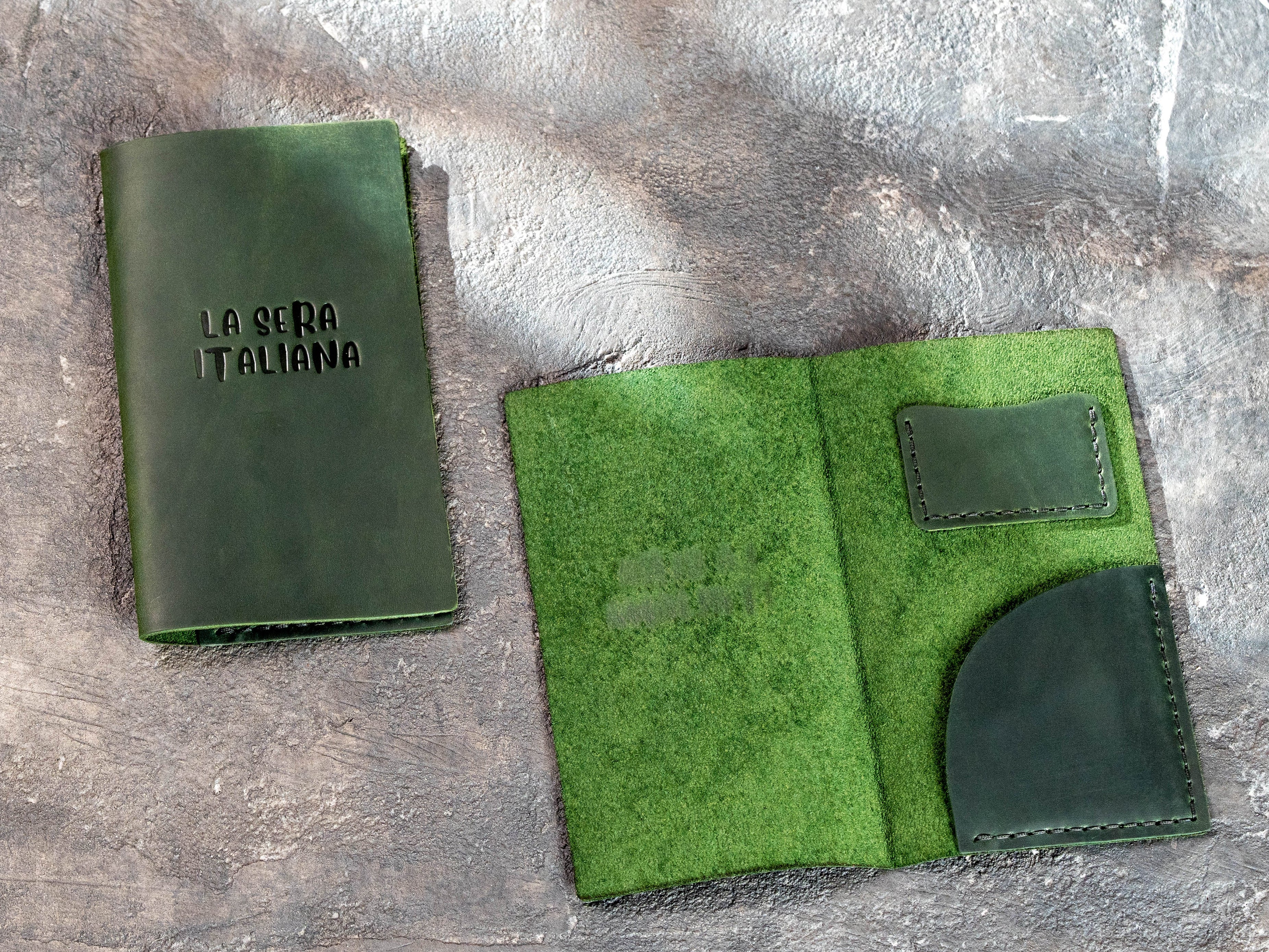 Green leather restaurant check presenter shown open with card pocket and curved receipt pocket