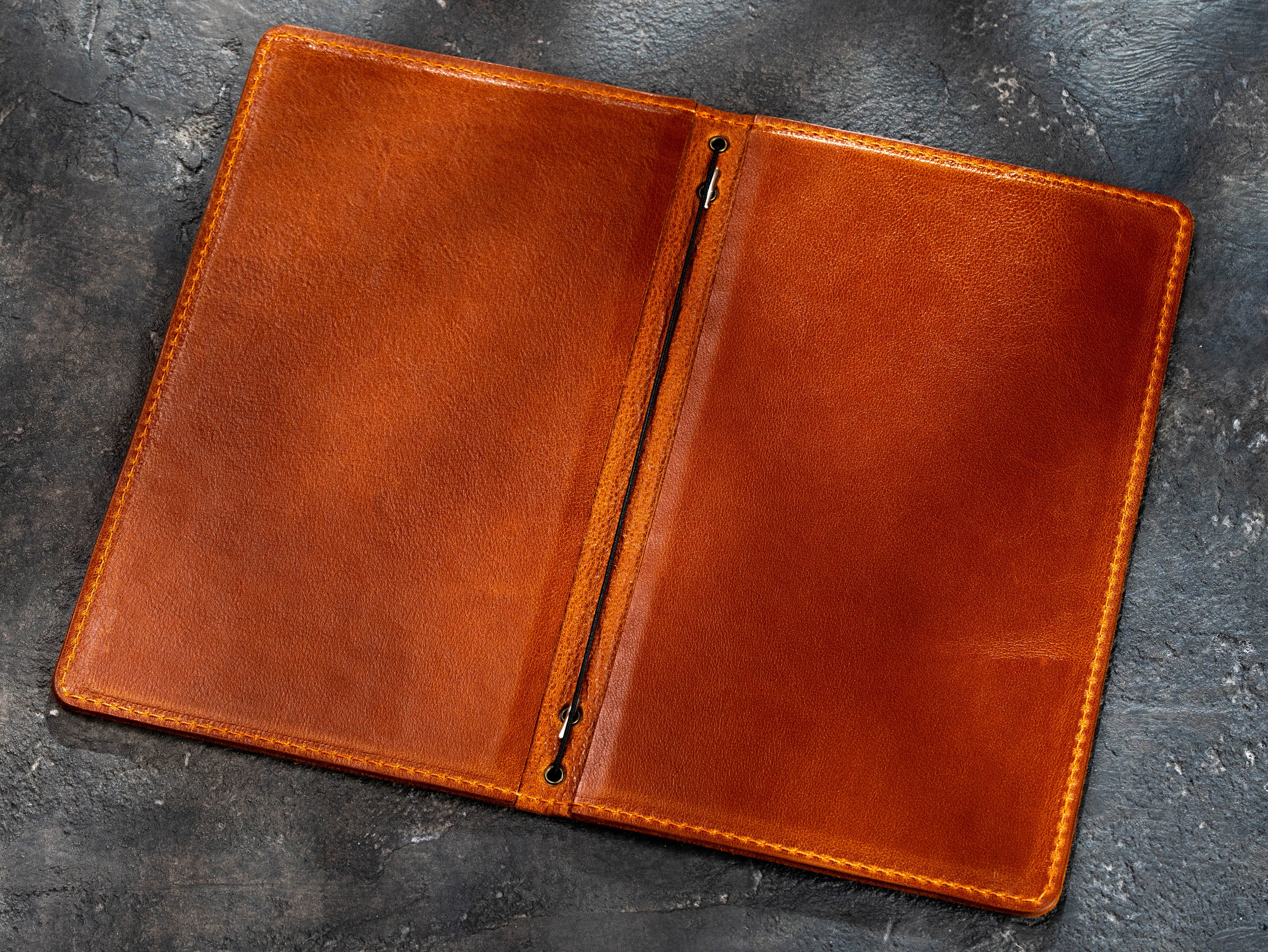 Open camel leather menu cover showing the double-layer construction and elastic binding
