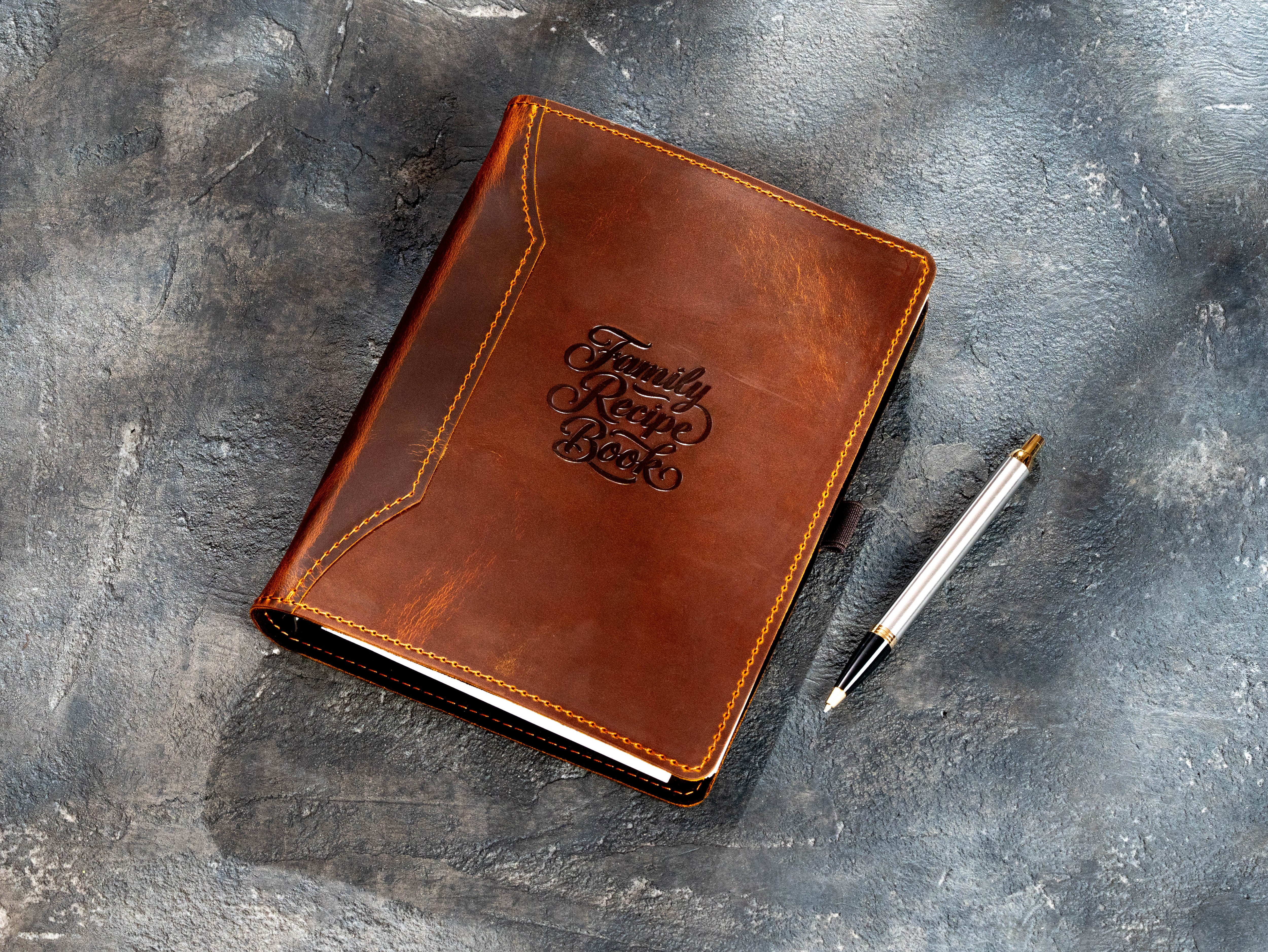 Chestnut leather recipe organizer with Family Recipe Book embossing and pen beside the cover