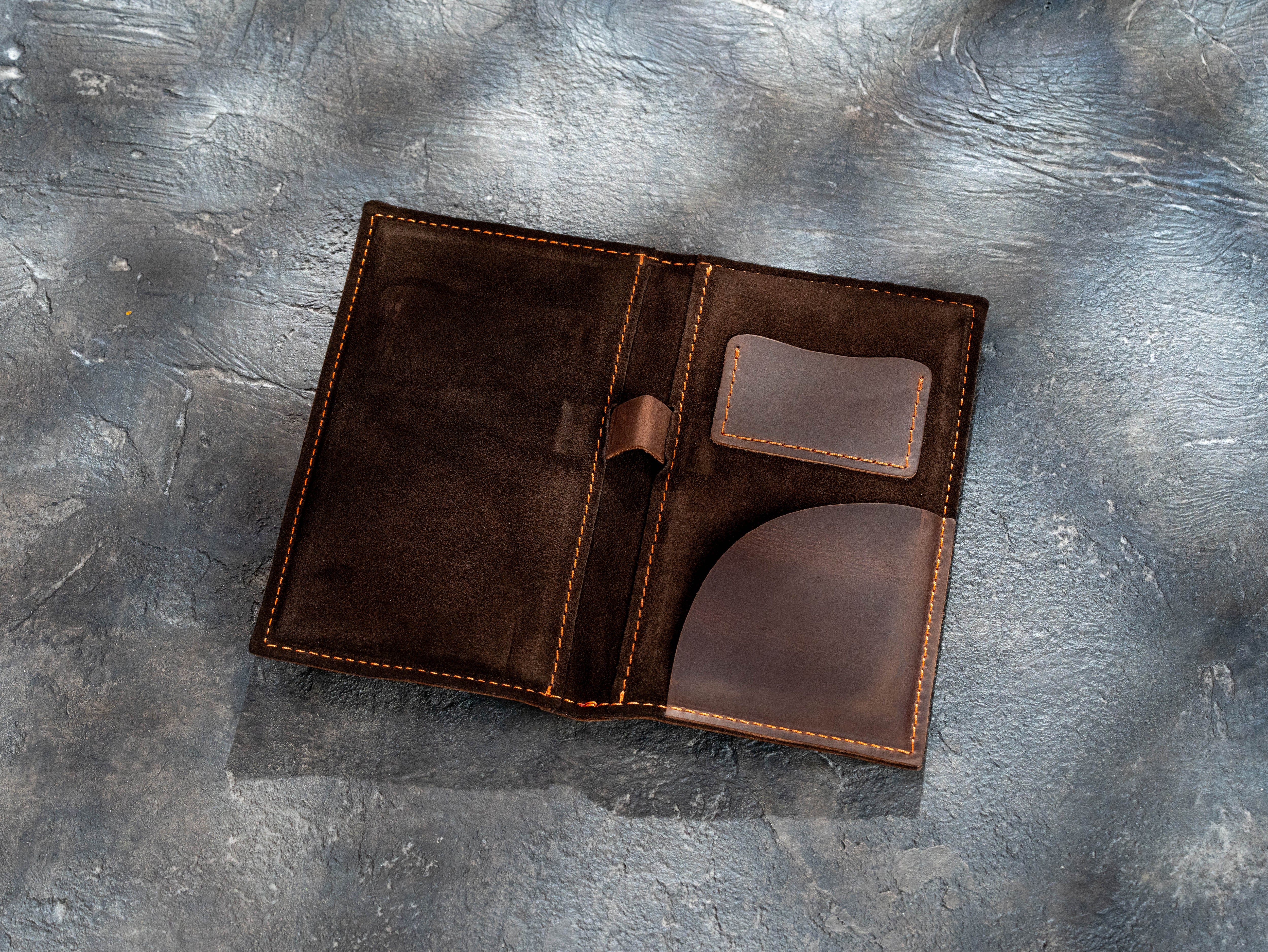 Open brown leather check presenter showing card pocket, bill pocket, and pen holder