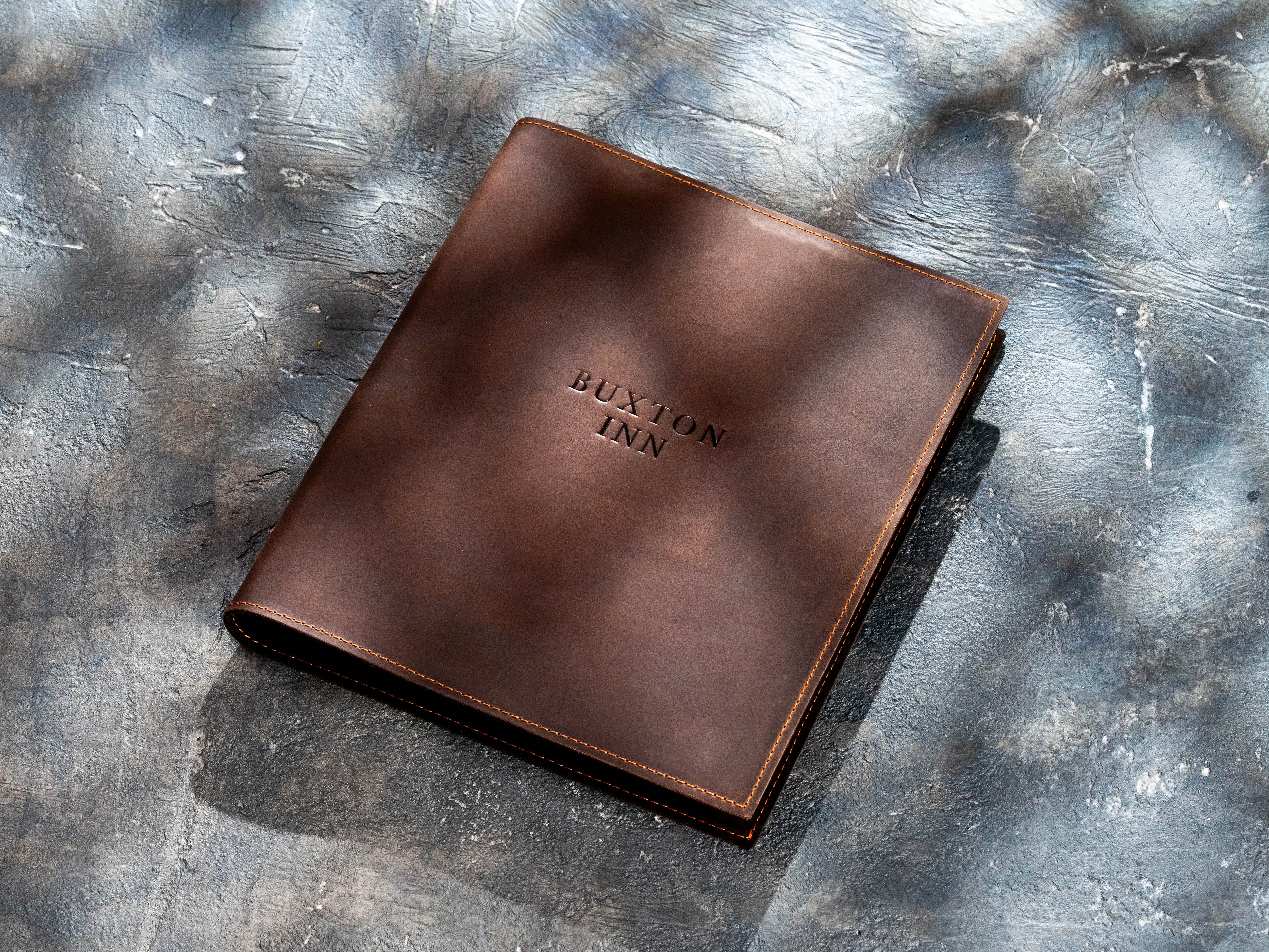 Brown leather binder with reinforced stitched edges and smooth structured cover