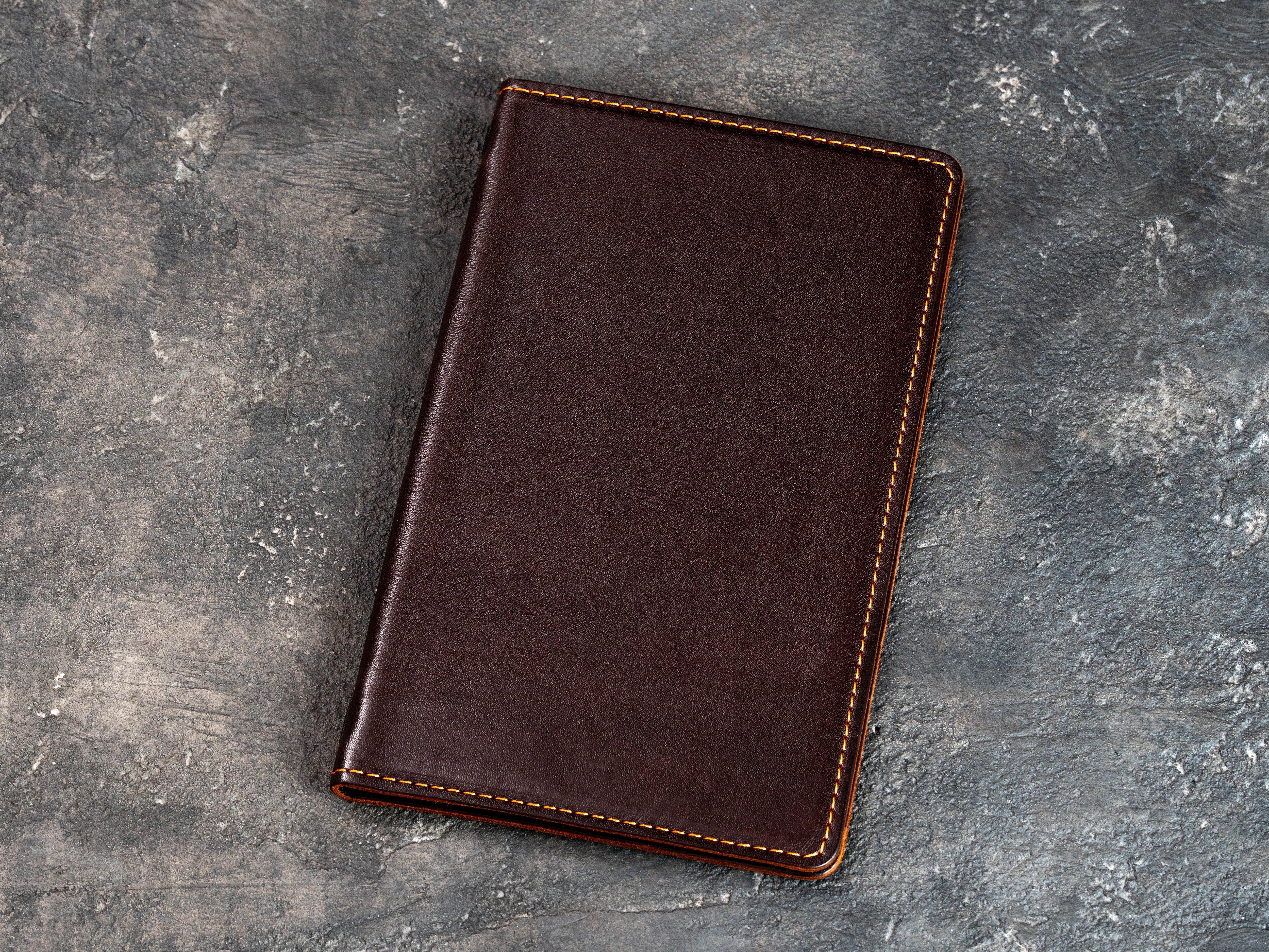 Front view of a closed cognac leather restaurant menu cover without branding