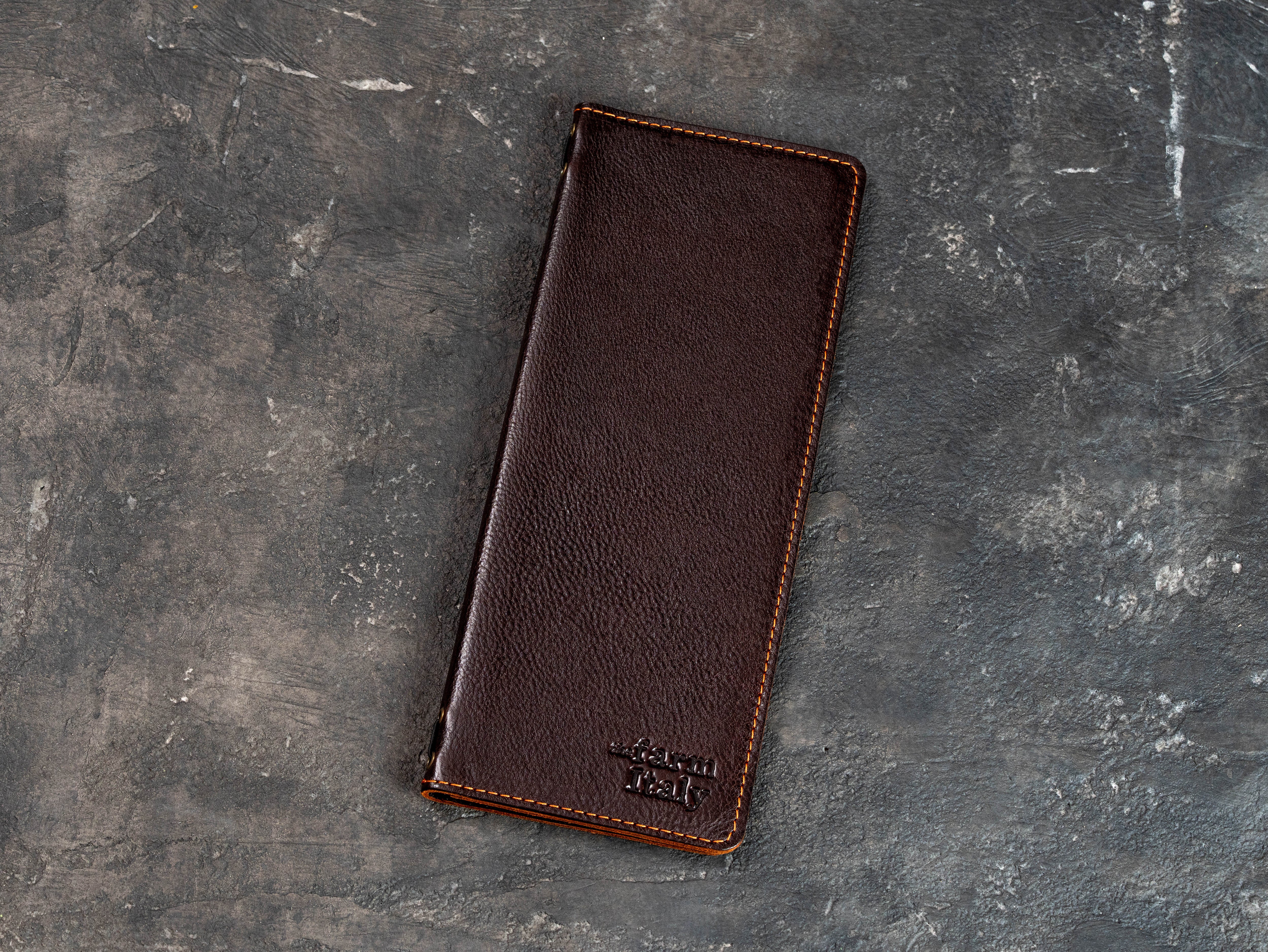 Closed dark brown leather wine menu cover with stitched edges and custom embossed logo