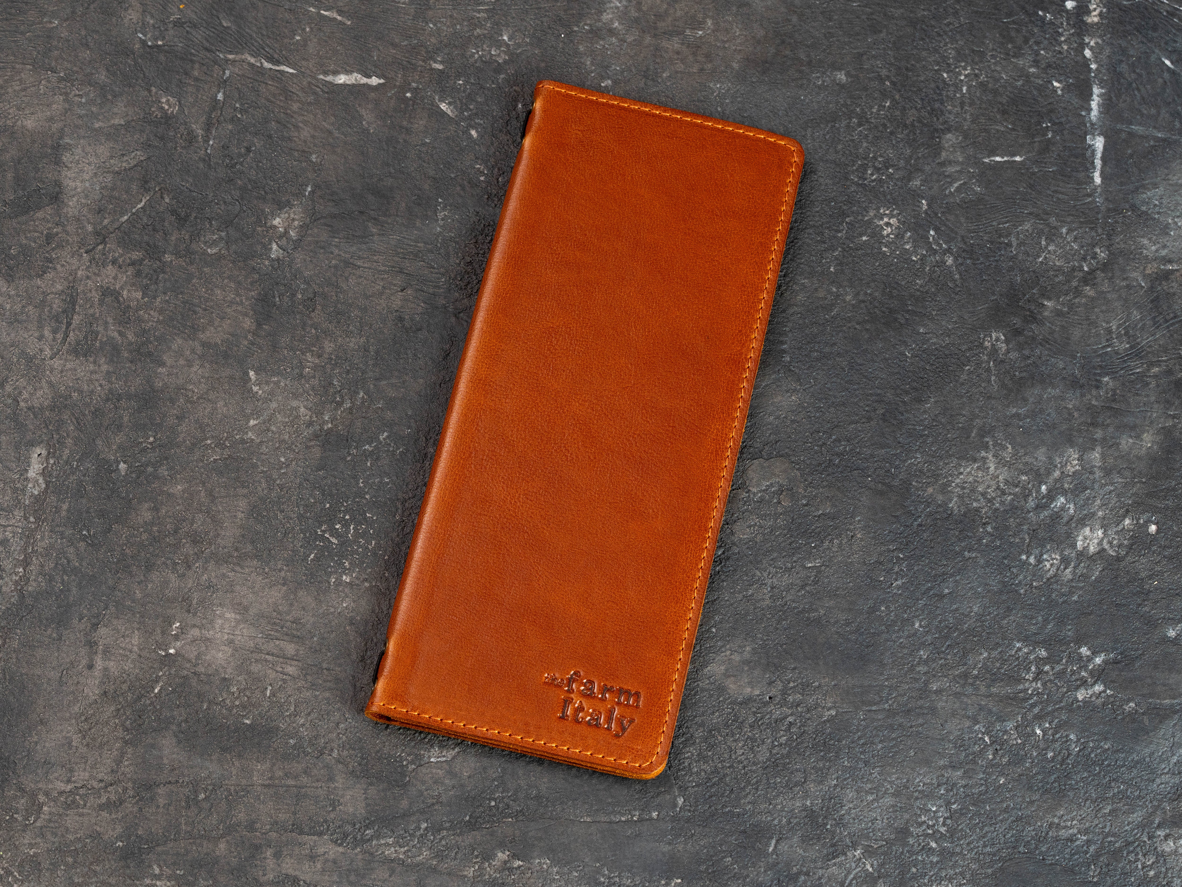Closed cognac leather wine and cocktail menu cover with stitched edges and custom embossed logo