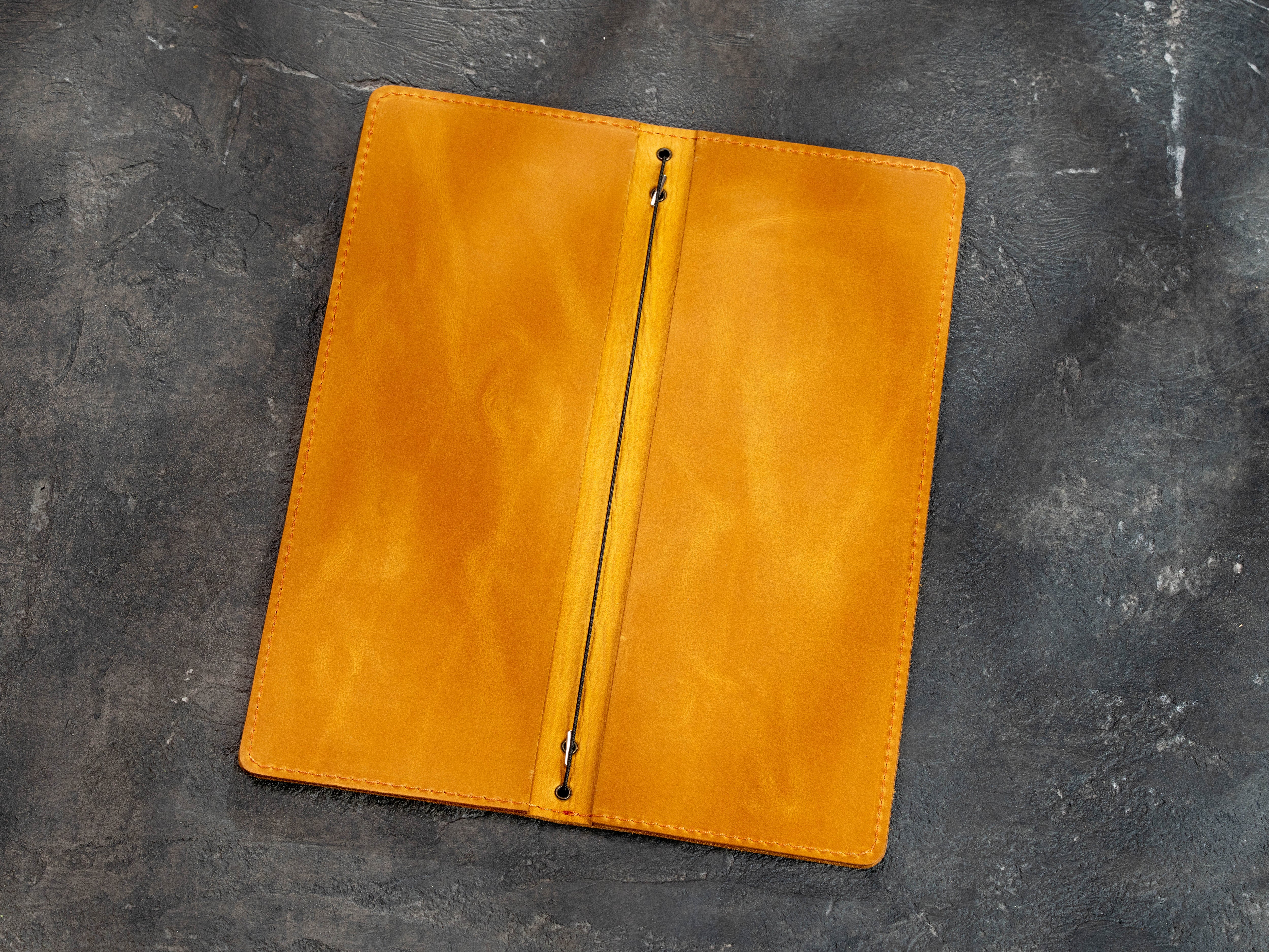 Open yellow leather menu cover showing the double-layer construction and elastic binding
