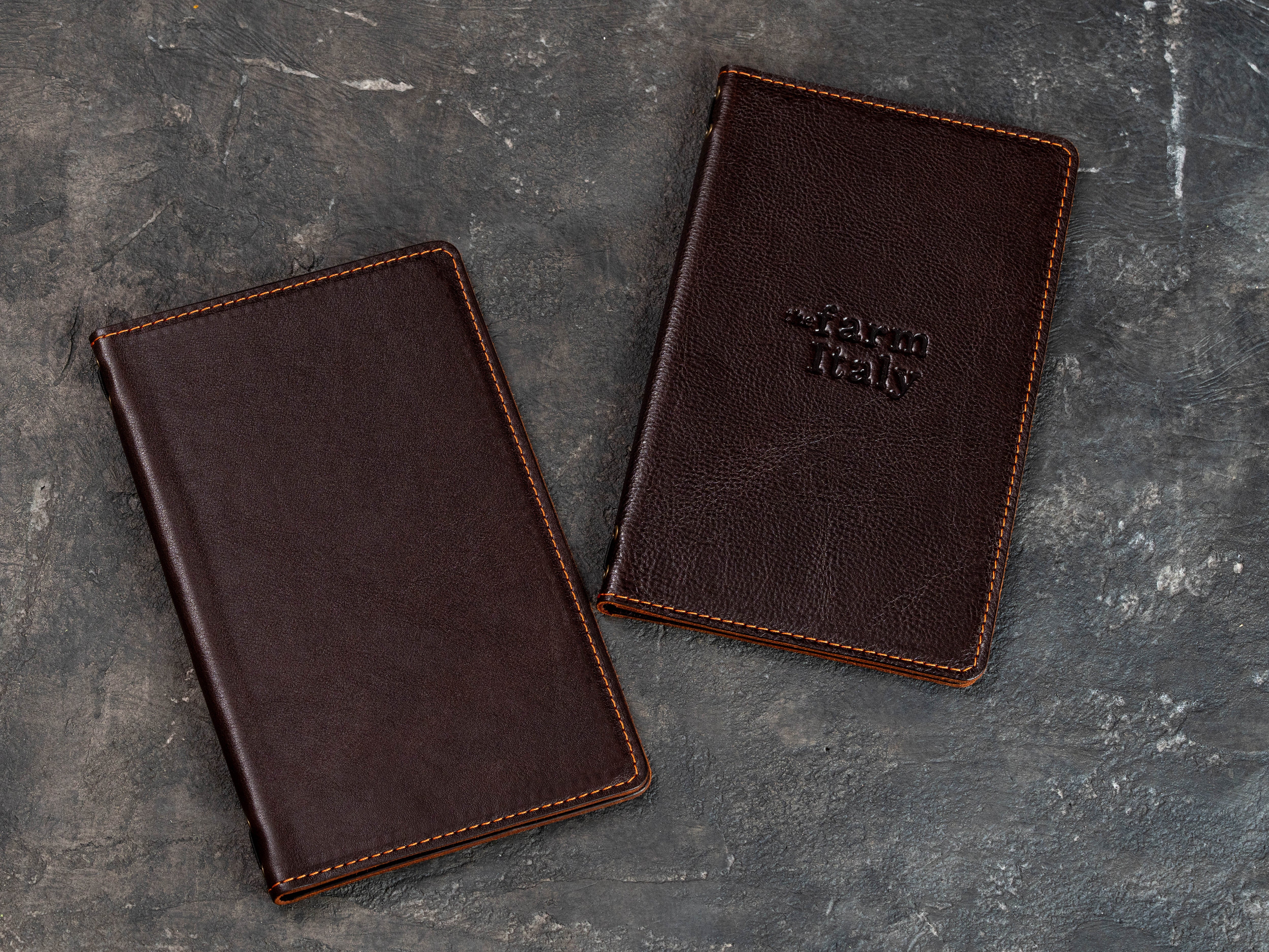Two cognac leather restaurant menu covers shown closed, including one with custom logo embossing