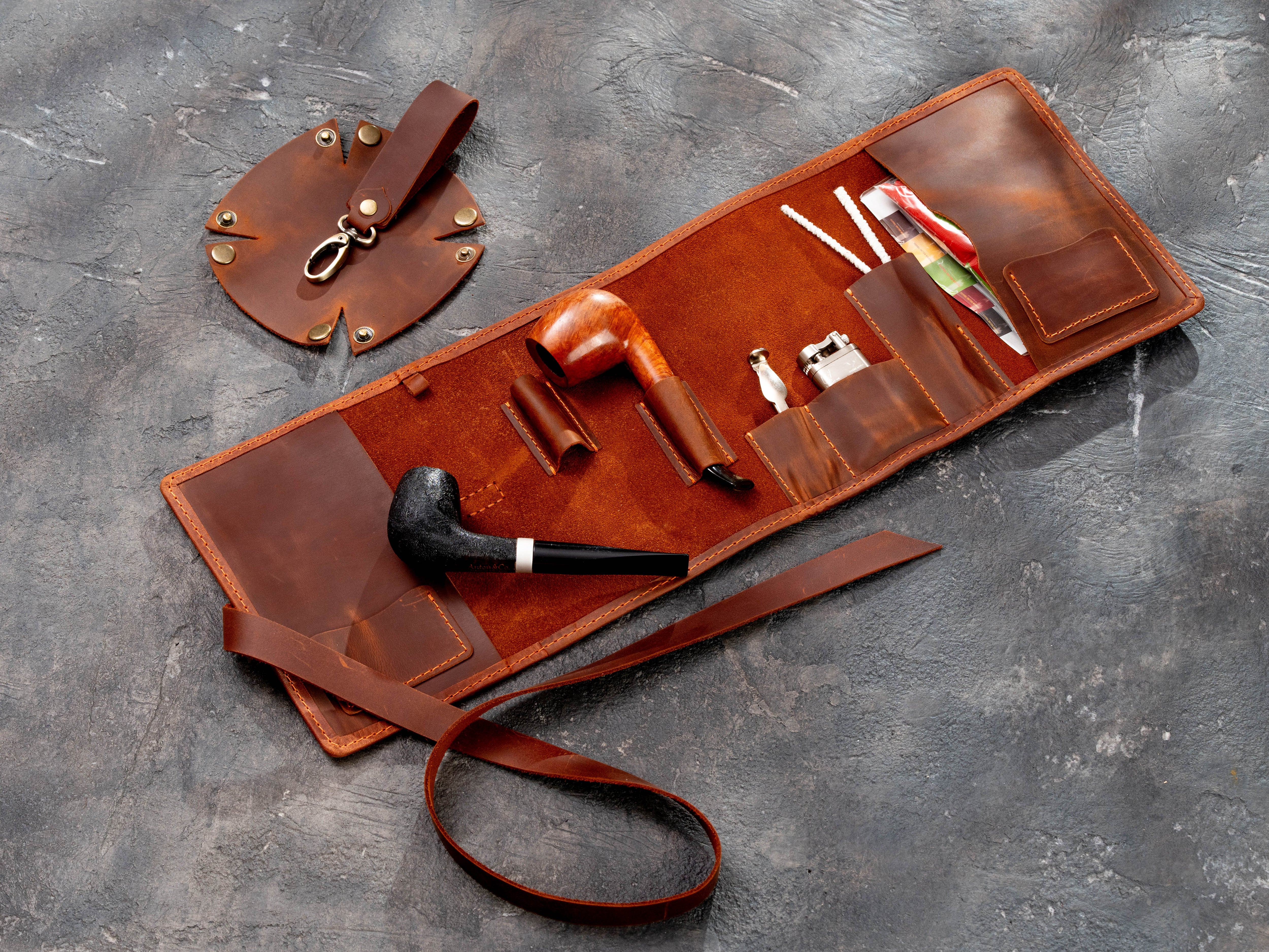 Open copper leather pipe organizer with accessories arranged in the interior pockets and holders