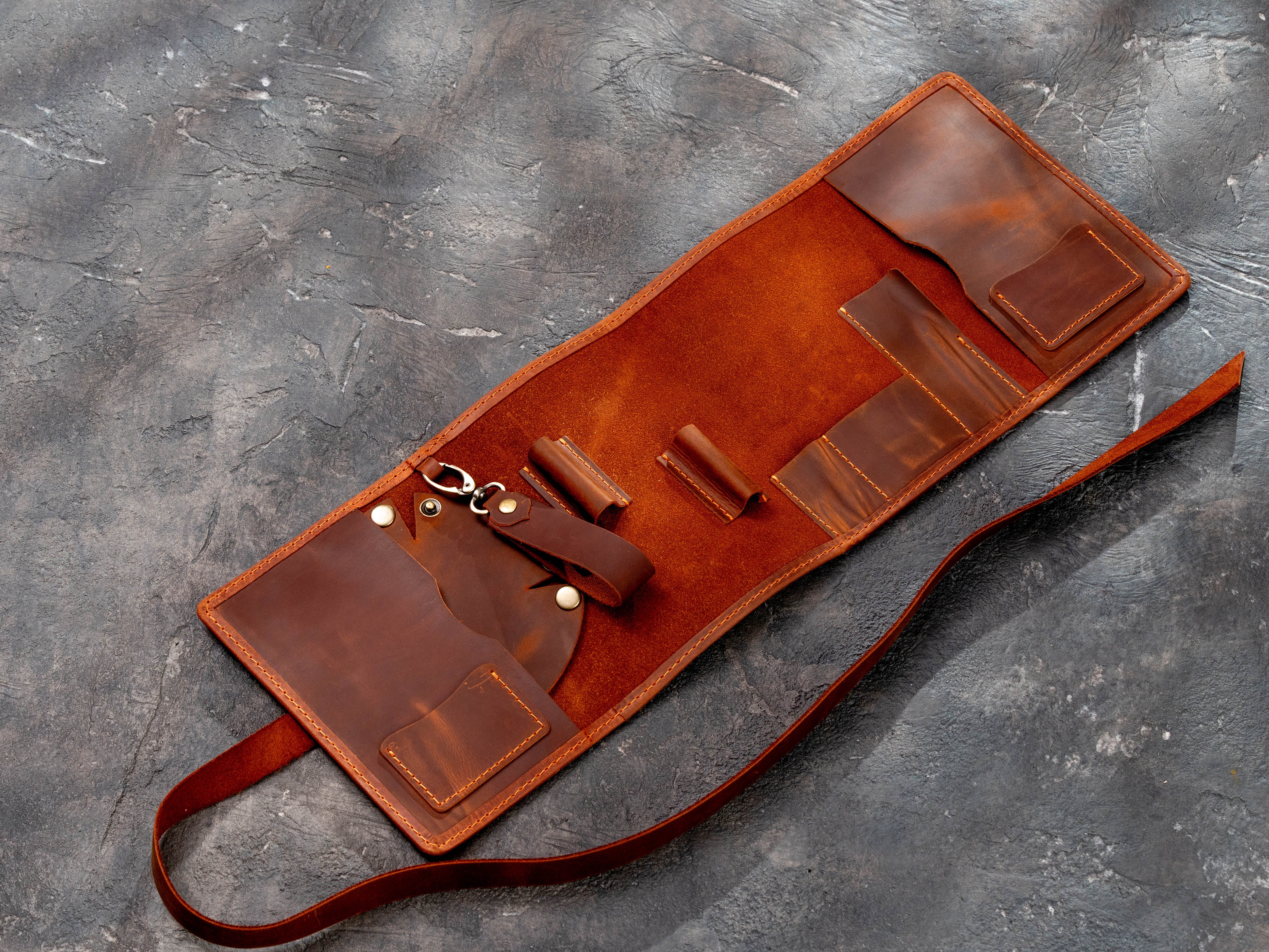 Open copper leather smoking pipe roll viewed from an angle with multiple accessory compartments