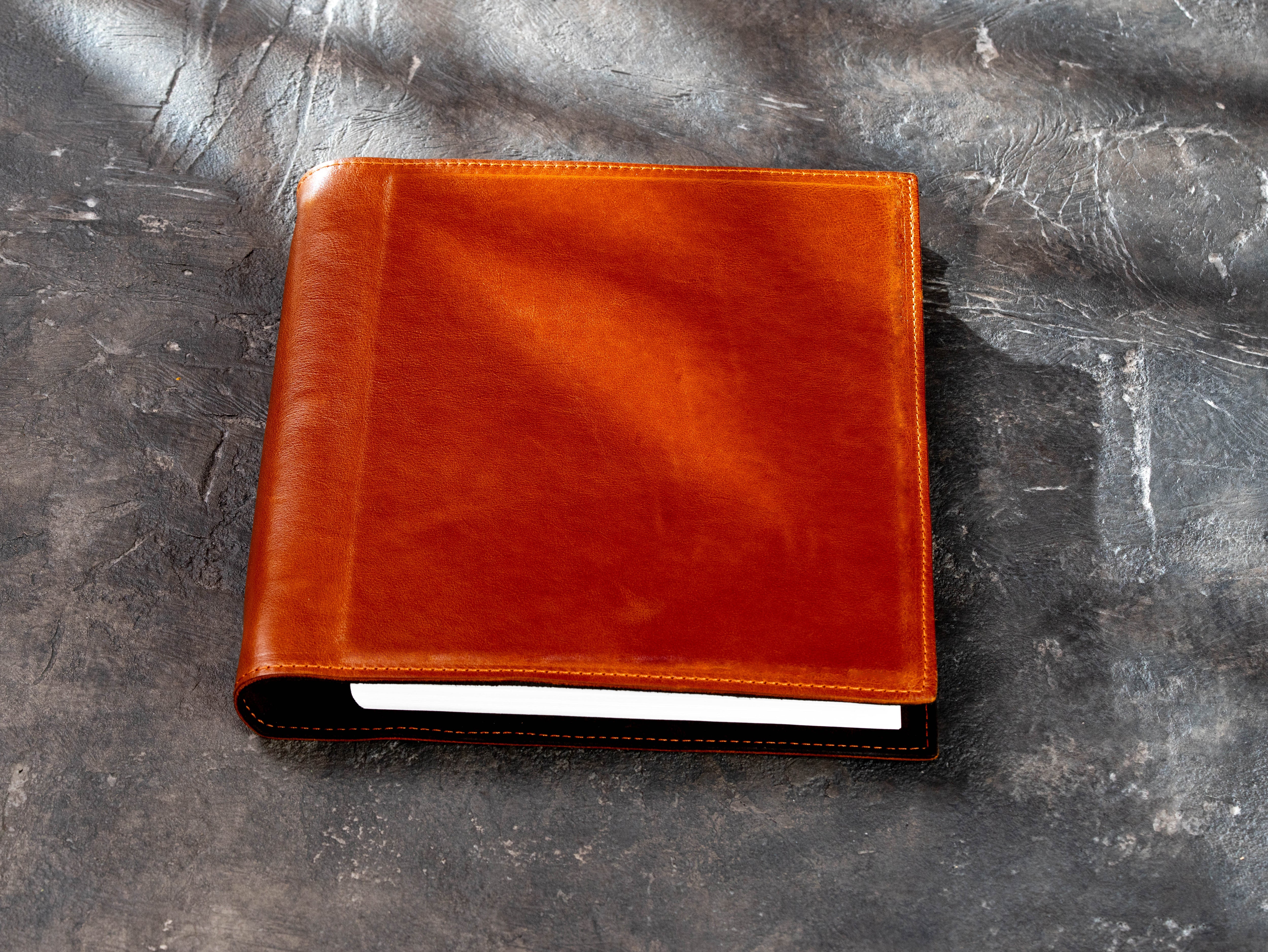 Closed camel leather 3-ring binder folder for 8.5 × 11 inch paper shown on a dark textured background