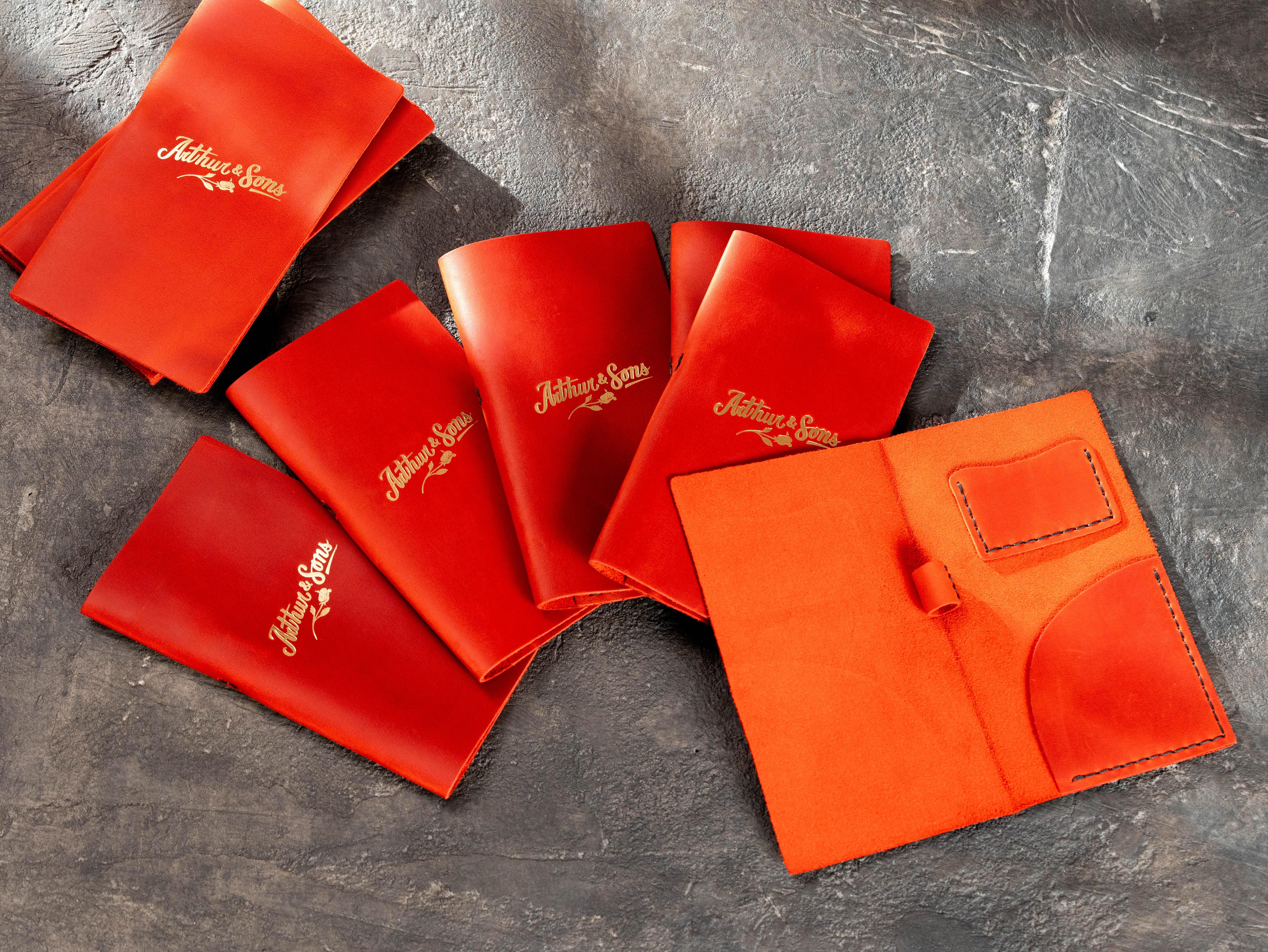 Bulk order of red leather check presenters with gold branding and functional interior pockets