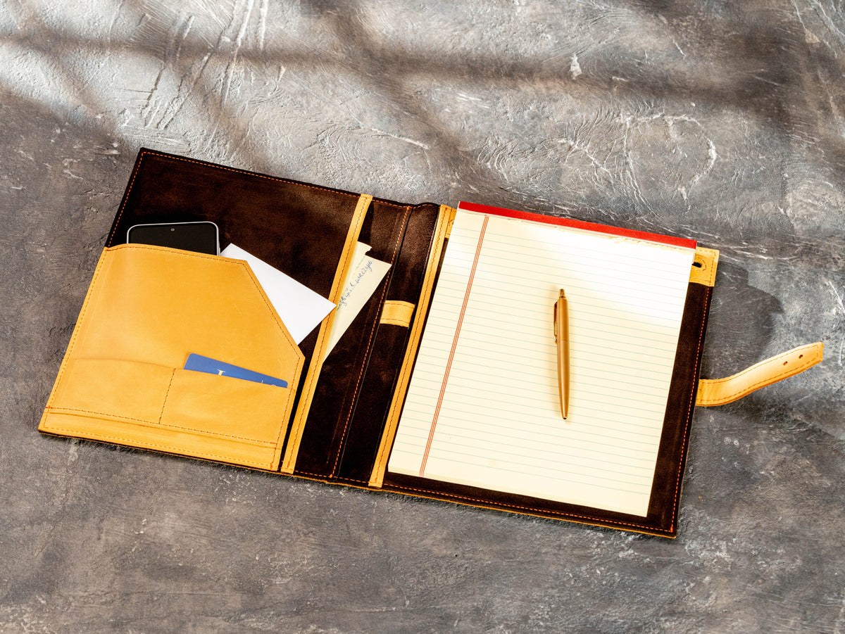wheat leather portfolio beside Legal Pad 8.5 x 11.75 inch notebook