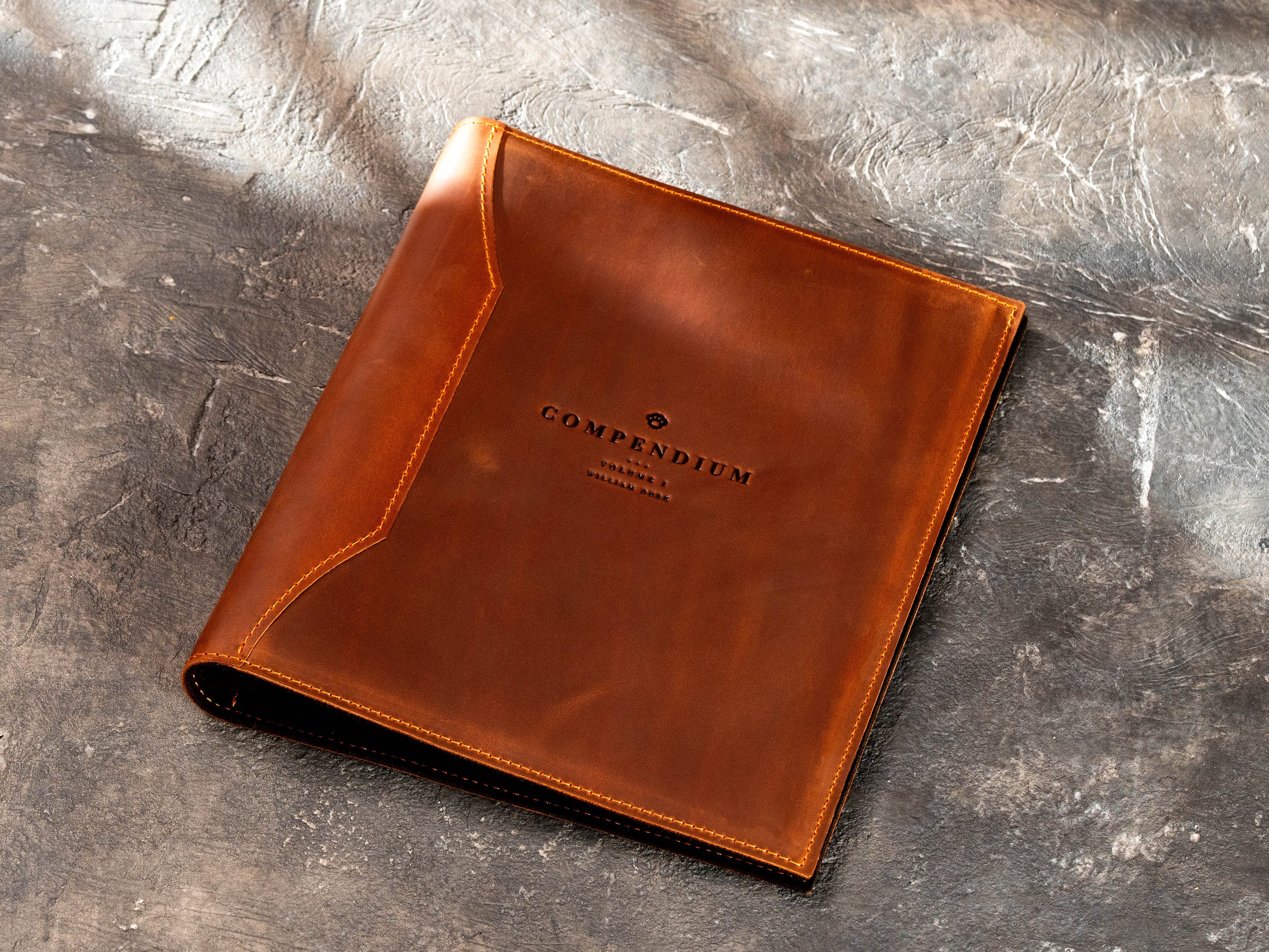 Custom leather corporate binder with Compendium logo for A4 and 8.5 × 11 inch business documents.