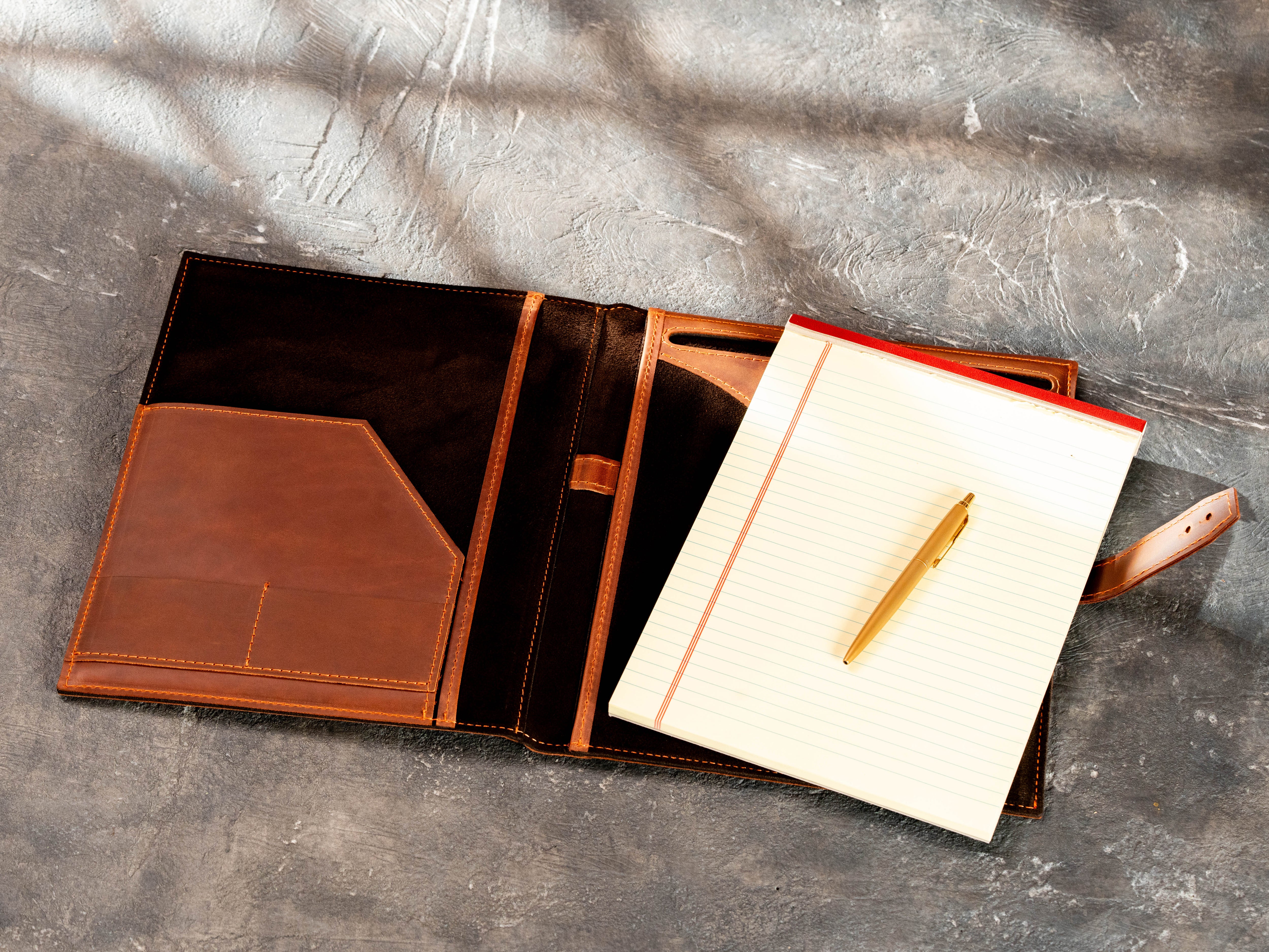 Open copper leather portfolio with 8.5 × 11.75 legal pad, document pocket and pen holder.