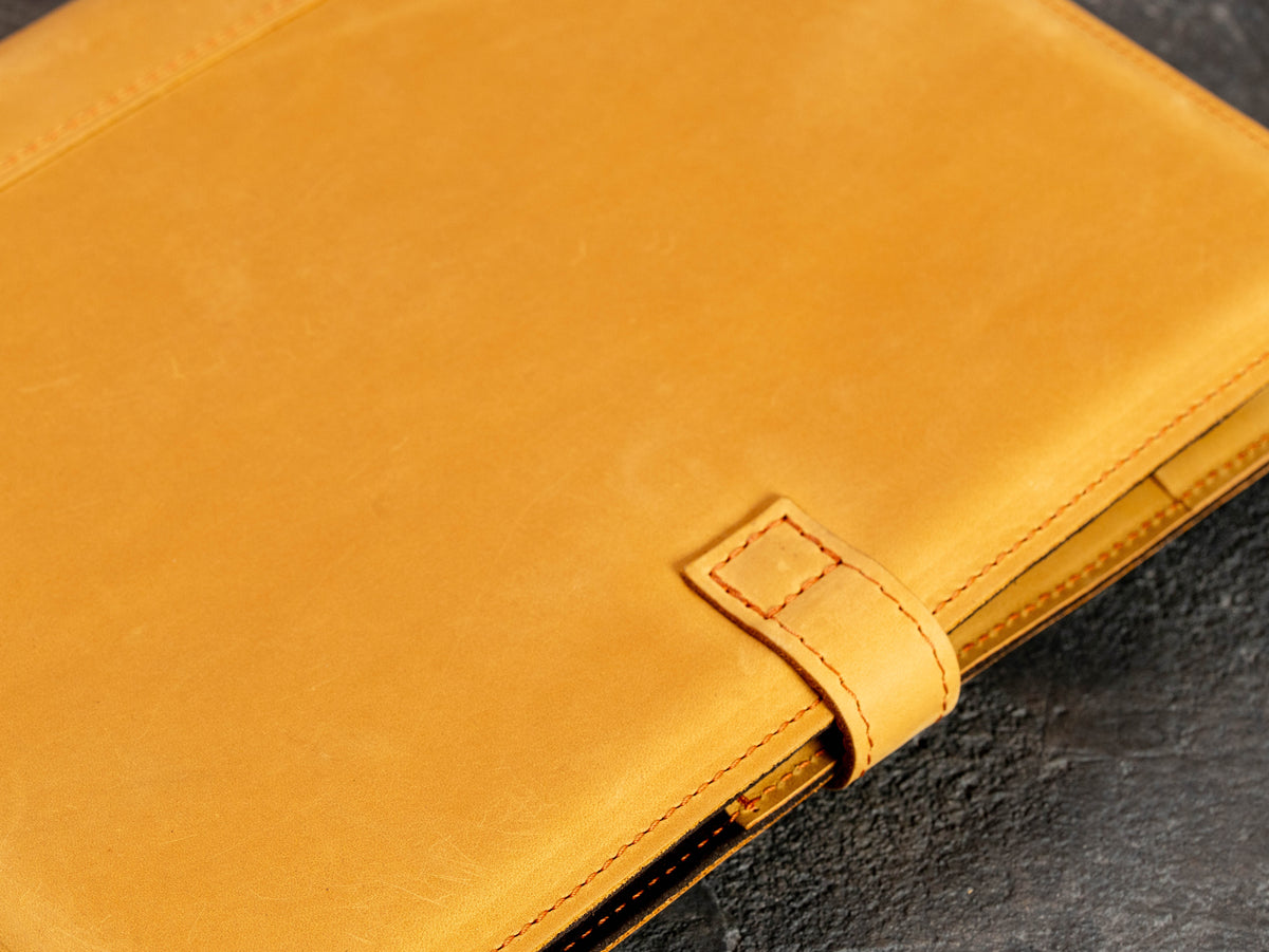 Close-up of leather strap closure and stitched edge on personalized business portfolio