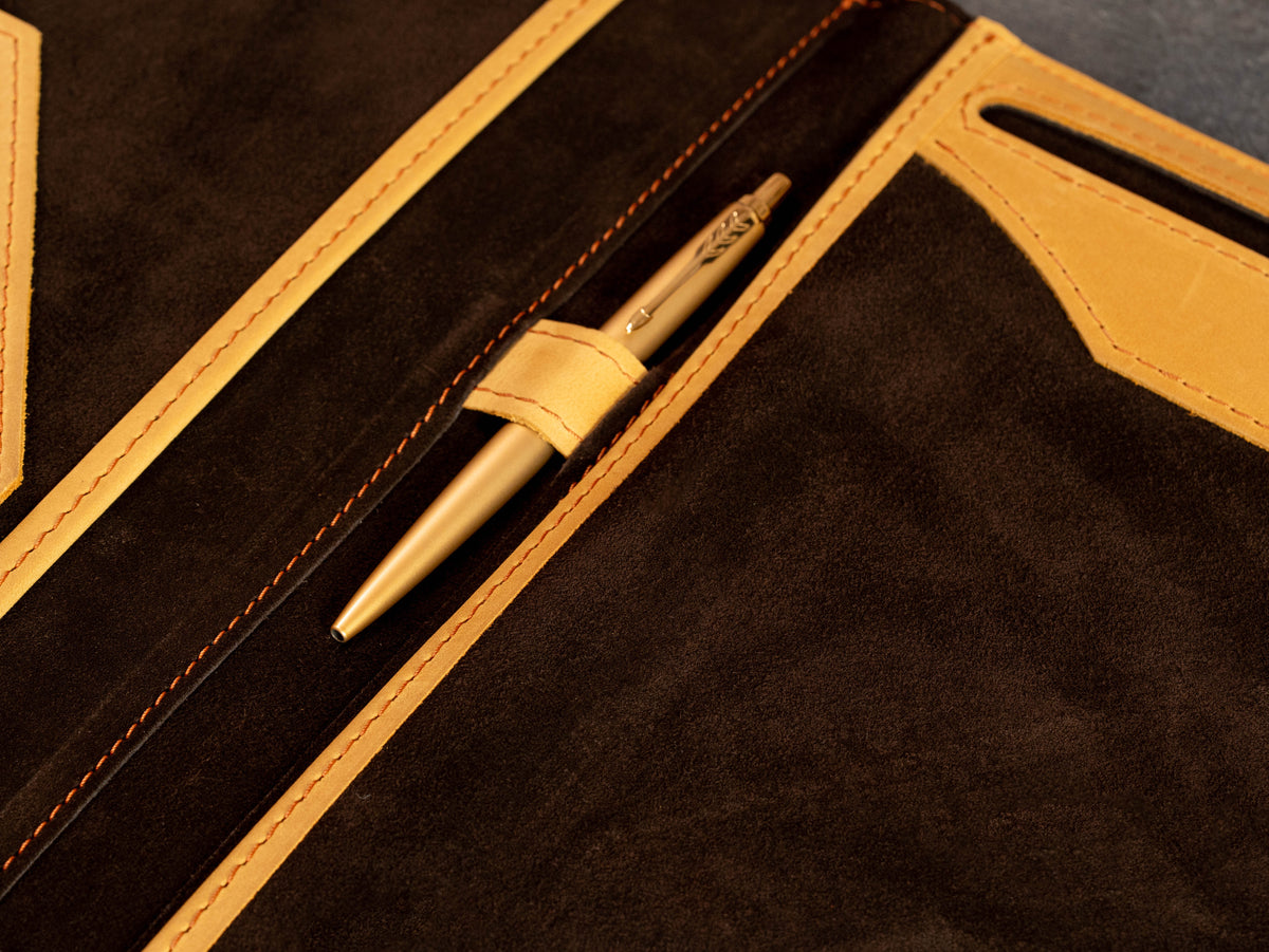 Close-up of leather pen holder inside brown suede business portfolio