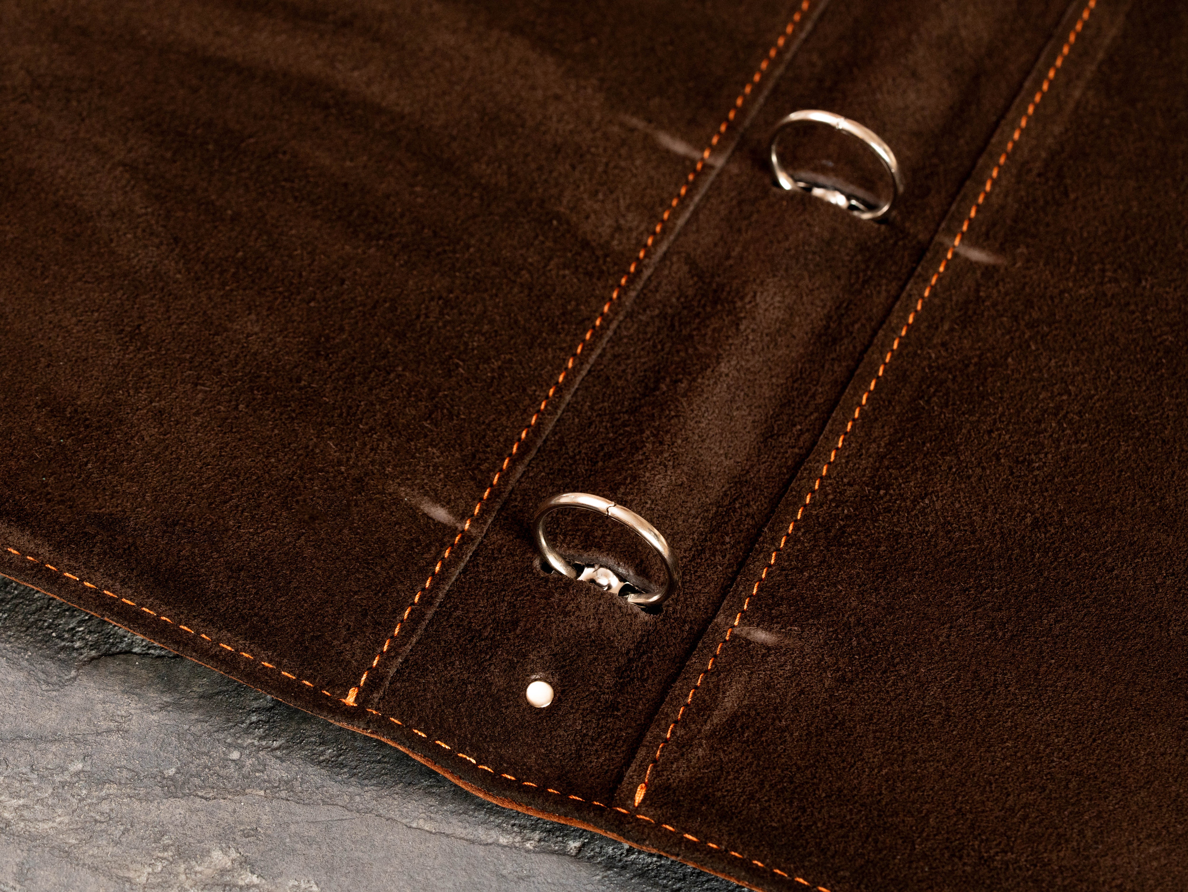 Dark brown suede interior of leather 3-ring binder with metal ring mechanism and detailed stitching.